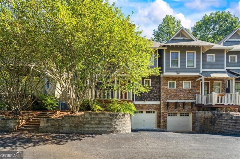 Welcome to The Seasons, one of Athens' most sought-after condominium communities! This stunning 3-story Craftsman-style, end-unit townhome offers the perfect blend of elegance, functionality, and convenience-just 5 minutes from Sanford Stadium and 10 minutes to downtown Athens. The terrace level features a one-car garage and a spacious storage area, offering plenty of room for practical needs or hobby storage. On the main level, enjoy an open-concept design with 9-foot ceilings and beautiful hardwood floors. The chef's kitchen is stunning, showcasing granite countertops, tile backsplash, a large eat-in island with seating, stainless steel appliances, a gas cooktop, custom cabinetry with built-in under- and over-cabinet lighting, and a generous walk-in pantry. A separate dining area with built-in display cabinet flows seamlessly into a cozy den anchored by a gas-log fireplace and built-in bookshelves-ideal for gathering or relaxing. French doors open to a private concrete patio, perfect for entertaining al fresco. The upper level is bright and inviting, thanks to a wall of windows and soaring ceilings along the staircase. The owner's suite impresses with two expansive closets, one featuring custom shelving, and a luxurious bathroom with dual vanities, jetted tub, and a large walk-in shower with pebble-style tile flooring. A thoughtfully designed desk nook in the guest bedroom adds versatility, while brand-new carpet graces bedrooms and hallways. A convenient laundry room includes washer / dryer hookups and storage cabinetry. Finally, for peace of mind, a complementary 1 year home warranty is being included with this home. The Seasons feels like a peaceful woodland retreat while offering in-town convenience. Residents enjoy a quiet, well-maintained environment surrounded by mature trees and greenery, with minimal exterior maintenance required thanks to HOA care. The Seasons is just minutes from UGA, the Vet School, downtown Athens, and Five Points-making it the ideal blend of natural setting and access to urban amenities.