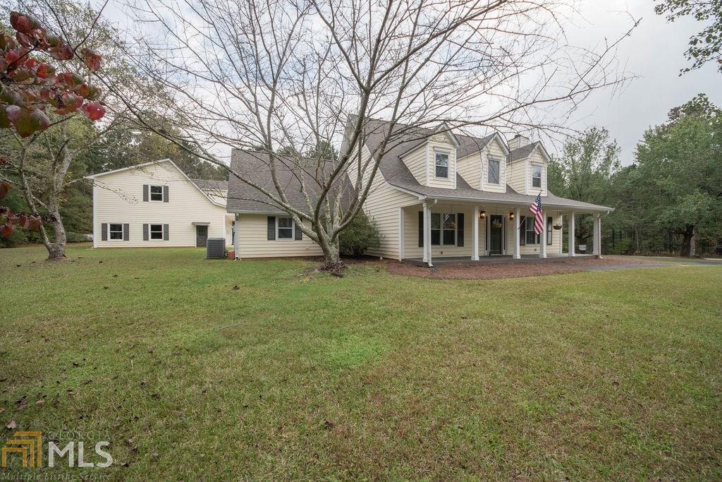 This classic home has it all! Tons of square footage and room to spread out indoors and a HUGE 2.6 acre corner lot with loads of potential for a pool, garden, and so much more! On the main level you'll find a rocking chair front porch that opens into the large living room with cedar shake flanked fireplace. There is a nice big dining room with loads of windows and french doors that lead out to the covered rear porch. The kitchen is very spacious with a pantry and plenty of space for a breakfast table, plus real wood cabinets, big single bowl sink with bridge faucet, new stainless dishwasher, stove & built-in microwave. There's a powder room off the hall perfect for visitors and the master suite is also on this level featuring a walk-in closet, on-suite bathroom with double vanity, new granite counters, big jetted soaker tub, separate tiled shower and new LVP floors. Finally on the main level you'll enjoy the huge multi-purpose room with separate outside entrance so it's perfect for entertaining or kids to use and has a large storage closet with barn door and large laundry room. The upper level has two nice sized bedrooms, a full bath and a large bonus room/4th bedroom. Outside you'll find even more to love with the massive flat corner lot that has lots of mature trees plus a huge detached garage with stairs to an unfinished area that could be an office, studio, apartment or just a great place to store all the extra stuff! The charming circular drive leads to the front walk or to the rear paved parking area with so much room for vehicles, boats, camper, ATV, etc. Excellent Coweta County schools- Willis Rd Elementary, Lee Middle, and East Coweta High. The location cannot be beat with easy access to EVERYTHING - Interstate 85, Peachtree City, downtown Newnan, shopping, restaurants, Cancer Treatment Center, hospital, Sam's Club/Costco (just 3.4 miles), etc!