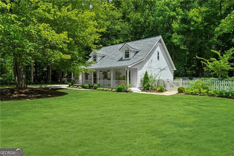 Welcome to your completely renovated haven in the heart of downtown Alpharetta, where charm meets modern sophistication on a sprawling .69-acre lot! This delightful 3br 2.5ba home offers the perfect blend of comfort and style. Step inside to discover stunning white oak wide plank hardwood floors that flow throughout the home, creating warmth and elegance in every room. The primary suite is conveniently located on the main level, spa like bathroom with floating vanities, frameless glass shower and designer lighting. The living room captivates with a vaulted ceiling and cozy wood-burning fireplace complete with gas starter. The open kitchen serves as the heart of the home, featuring stainless steel appliances, oversized island, designer tile, quartz countertops and a charming breakfast nook with bay windows that frame views of the beautifully landscaped outdoor entertaining area. A spacious dining area on the opposite side of the kitchen provides ample space for hosting family gatherings. Secondary level offers two bedrooms and a full bathroom, with ample storage and closet space. Completely redesigned landscape featuring boulder walls, pea gravel entertaining areas, complete irrigation system, lush Zoysia sod, mature trees, and plantings all enclosed within a quintessential white picket fence. Thoughtfully designed low-voltage lighting illuminates the home and yard, with enchanting firefly lights dancing among the trees from dusk to dawn. Enjoy a short stroll to your favorite restaurants and shops, welcome home!