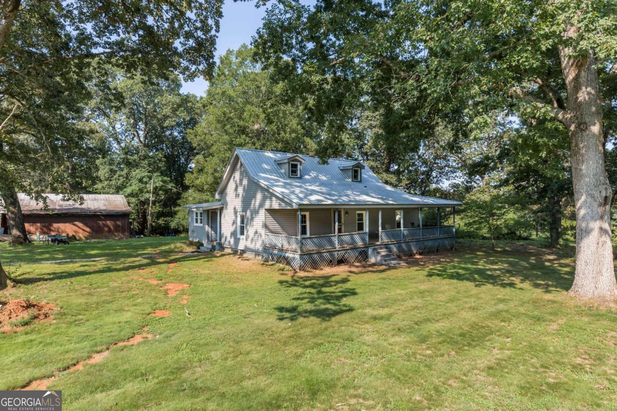 6 AWESOME ACRES of POTENTIAL on this beautiful level property of pasture and shade trees! COME AND 'SIT A SPELL' ON THE COVERED FRONT PORCH - SOAK UP THE PEACEFUL ATMOSPHERE OF THIS RENOVATED COUNTRY BUNGALOW CHARMER. UPGRADED APPLIANCES, FIXTURES, NEW VINYL SIDING -ALL NEW WINDOWS Beautiful NEW HARDWOOD FLOORS throughout, Beamed Bead Board Ceilings for a Country Rustic Look. Home is accented by some of the original wood door and trim to preserve the history yet updated floors, ceilings, upgraded appliances, granite counters and fixtures. Rooms include Spacious Living Room, Dining/Den , Master suite that adjoins a 2nd bedroom/office via a Jack and Jill style Bath plus a large 3rd bedroom. Home offers plenty of living space would make a great vacation home in beautiful northeast GA mountain area. NOTE: 6 ACRES Could be subdivided And the current LI Zoning allows for commercial options. HUGE 3 BAY SHOP 52x40 12' Ceiling WITH LIFT AND AIR COMPRESSOR included. The property is just minutes from the 365 corridor and the convenience of shopping and restaurants yet preserves a country vibe. Many options whether residential, a mini farm, a business, short term rental , subdivide for additional homes etc etc etc.