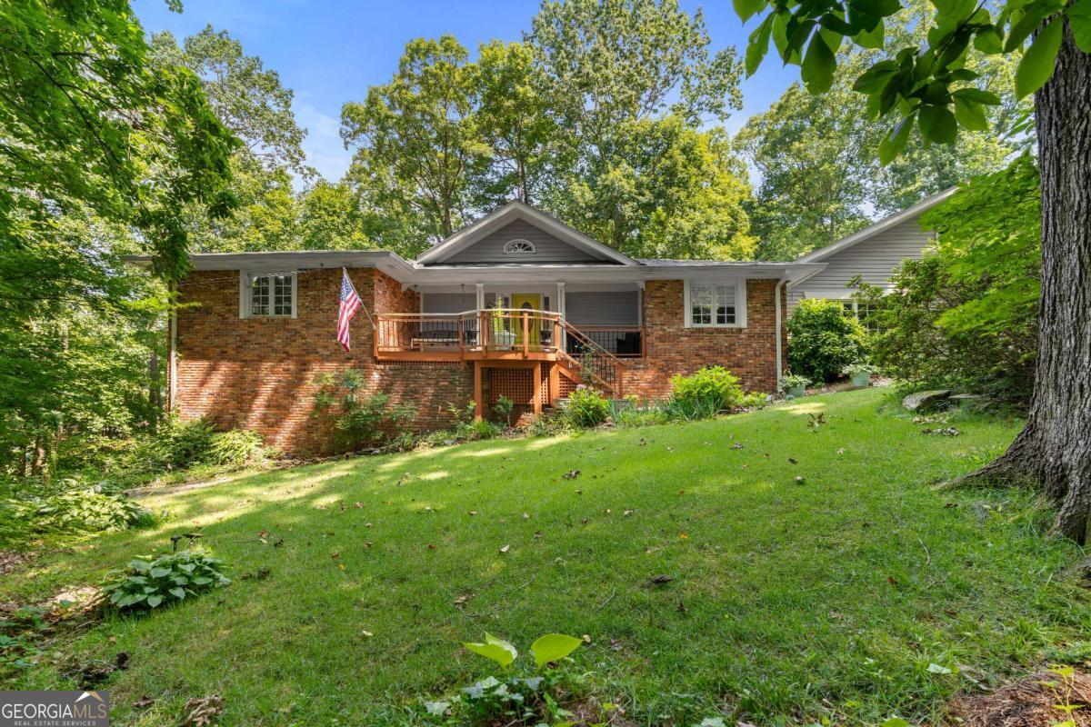 Tucked away on a lush, wooded lot, this beautiful 3-bedroom, 3.5-bath ranch offers the perfect blend of privacy, charm, and comfort. From the moment you arrive, the inviting front porch welcomes you into a home filled with natural light and character. Inside, you'll find a spacious layout with multiple living areas, including a cozy formal sitting room and a bright, vaulted family room with picture windows overlooking the serene landscape. The heart of the home is the open kitchen featuring granite countertops, stainless steel appliances, a breakfast bar, and ample cabinet space - ideal for both everyday living and entertaining. The oversized primary suite is a true retreat, highlighted by an arched window that frames beautiful treetop views. The ensuite bath includes a double vanity, tile shower, and granite finishes. Additional bedrooms are generously sized and accompanied by lots of natural light. Step outside to your personal paradise - a sprawling back deck perfect for grilling, relaxing, or hosting, and a peaceful lower-level deck nestled among the trees, ideal for enjoying the gentle sounds of the nearby creek. Bonus features include a dedicated home office with built-ins, hardwood floors throughout, and modern fixtures throughout the home. With timeless brick details and endless outdoor charm, this one-of-a-kind property is the perfect place to call home.
