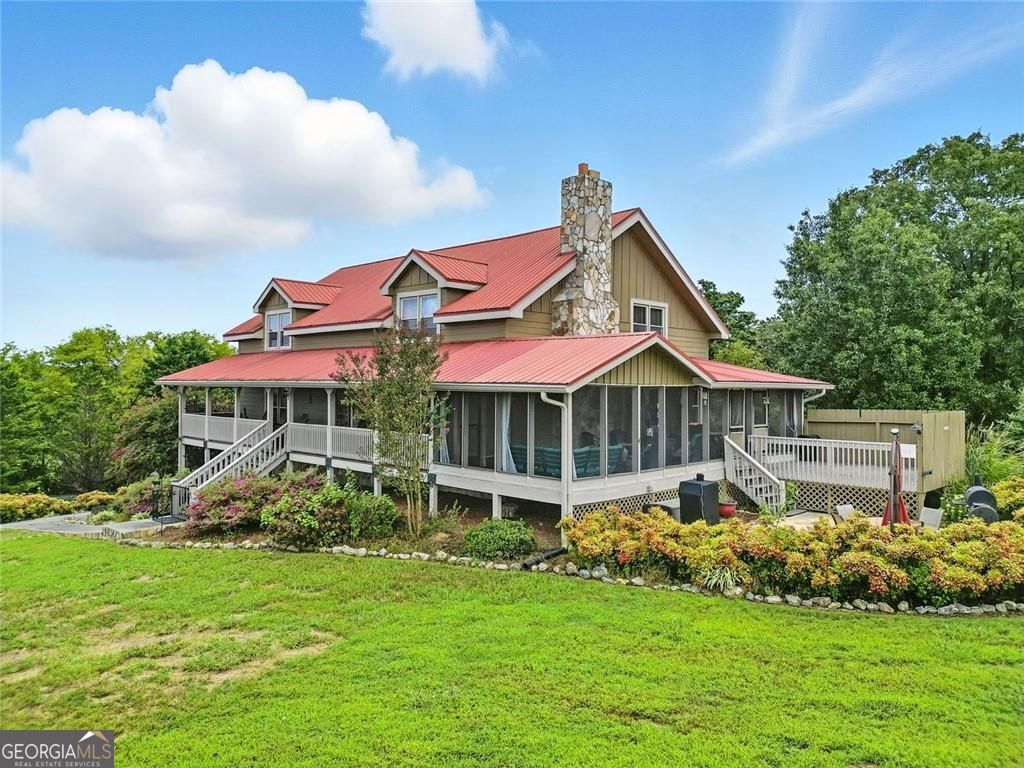 Welcome to your private countryside retreat-a custom-built home that has been lovingly held by the same family for generations and is now available for the very first time. Nestled on nearly 10 acres of serene landscape, this property offers endless possibilities: a peaceful homestead for your family, a weekend getaway with friends, or an investment opportunity with income potential from horse boarding and leasing. A long, tree-lined driveway sets the stage for ultimate privacy, opening up to a fenced pastureland and a warm, inviting countryside home with a striking red metal roof. The expansive wrap-around rocking chair porch, crafted from low-maintenance TREX composite decking, is the perfect spot to sip morning coffee, host gatherings, or watch sunsets over your open acreage. Inside, soaring two-story vaulted ceilings with tongue-and-groove finishes create a lodge-like atmosphere. The main level offers a spacious family room with a stone fireplace, open dining and kitchen area, and a walkout to a large screened-in porch and paved patio overlooking the property. The kitchen is designed for both cooking and connection, featuring a gas range and oversized walk-in pantry. The main floor also includes a half bath, laundry room, and a private primary suite with en-suite bath. Upstairs, a generous loft overlooks the main living area, accompanied by two spacious bedrooms and a full bath. The finished lower level expands your living space with a second family room which was preciously used as another guest bedroom, wood-burning stove, full bath, abundant storage, and direct access to the oversized two-car garage-complete with additional storage, upright and chest freezers that remain. Surrounding this home are and not fenced are 3 +/- acres feature a well house, outbuilding, fenced dog run, and former garden plots ready to be revitalized. For equestrian lovers, the 7 +/- acres of fenced pastureland boasts a 3-stall horse barn with tack room, water, and electricity, offering the perfect setup for your own horses or as an income-producing boarding facility. Though you'll feel miles away from it all, this sanctuary is just 10 minutes to I-75, 14 minutes to downtown Adairsville, and 20 minutes to Cartersville-providing the ideal blend of seclusion and convenience. Whether you're searching for a private family estate, an inviting weekend escape, a corporate retreat or a smart investment with income potential, this one-of-a-kind property delivers peace, privacy, and possibility.