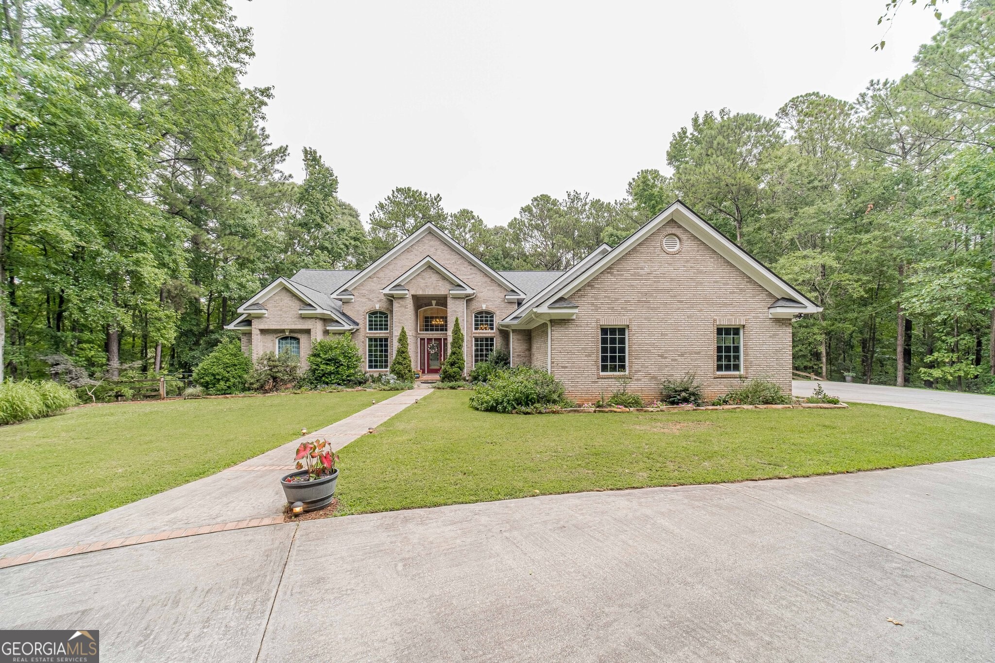 Be blown away by every gardener's dream garden as you enter the gates to this 5 acre sanctuary with a babbling brook. Beautiful all brick home with plenty of room to entertain or relax in the peaceful outdoors.  As you enter the home you are greeted with windows overlooking the back deck. Enjoy a good book in the formal living area taking in the scenery. Lage formal dining room is perfect for holiday gatherings. Includes three bedrooms and an office that could be used as a 4th bedroom! The spacious primary suite has a sitting area that opens to the covered back deck and includes an ensuite with his and hers vanities and separate closets. The open kitchen features a breakfast room, stainless steel appliances, and plenty of cabinet and counter space! It is also open to the family room complete with fireplace for the cold winter months. Two additional bedrooms share a jack and jill bathroom and round off the main level. The finished terrace level features a large den, bedroom, kitchenette, media room, two full bathrooms and tons of storage. A workshop w/ boat door will house all outdoor equipment or additional cars! Schedule your showing today!