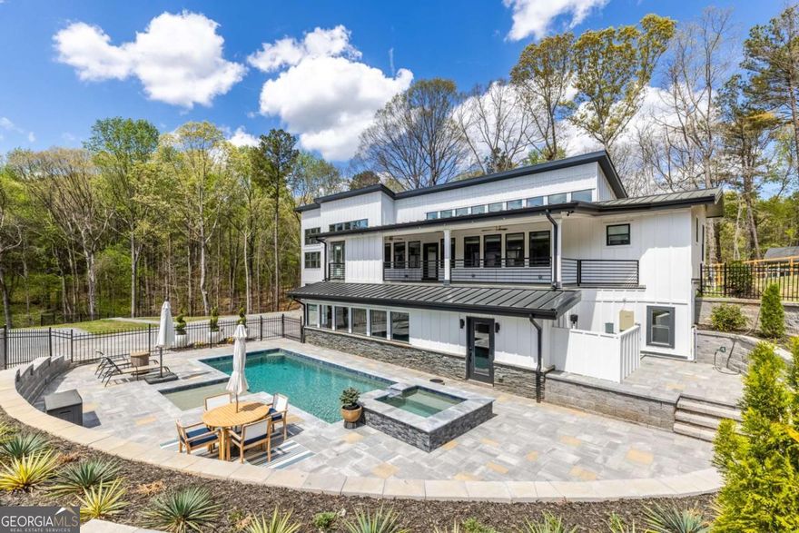 Welcome to 3350 Wildwood Rd, the latest trophy property located in the city of Suwanee. This home has been meticulously updated to enhance its modern features throughout, and provide functionality. As you drive in on your private paved driveway, you're greeted by a one of a kind estate is sure to impress. Featuring 6 rooms and 5.5 bathrooms. This spacious property offers a private layout with high-end finishes throughout. The home includes two primary suites, including one on the main level providing privacy for family members or guests. The main level highlights an open layout connecting the gourmet kitchen, to the oversized butlers pantry, for easy hosting. A formal dining room is ideal for gatherings, while a separate living or sitting area provides additional space to relax or host guests. Throughout the home, you find tall ceilings, abundant natural light, and refined details that elevate each space. This property also features a custom built, private indoor space perfect for hosting events, celebrations, or gatherings, offering a unique venue-like setting right inside your home. Step outdoors to enjoy an 8-foot-deep heated saltwater pool, surrounded by a well-maintained yard ideal for entertaining and outdoor dining. Recent renovations include new electrical, plumbing, and mechanical systems. The location is unrivaled, located in a prime area close to shopping, restaurants, parks, and top-rated schools, this home sits right off McGinnis Ferry Road with easy access to I-85. Schedule your showing today!