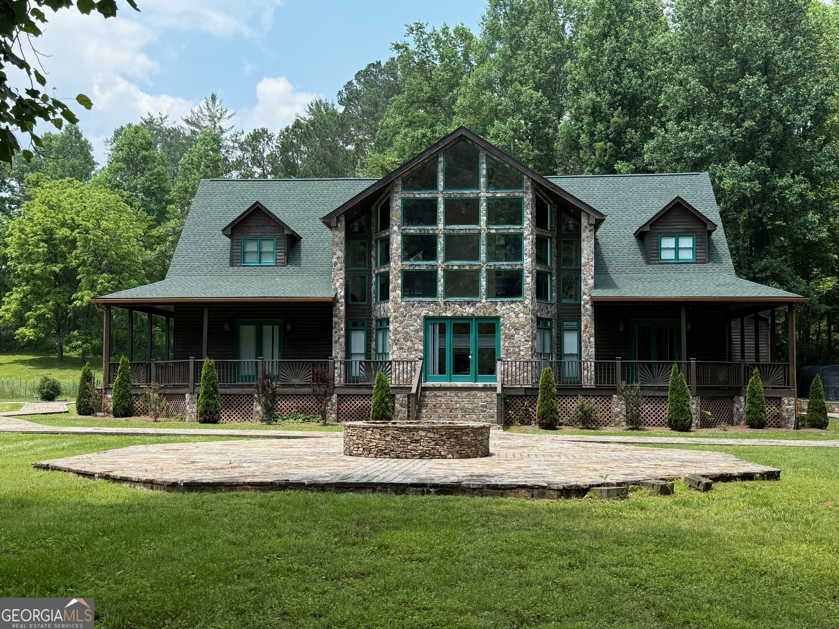 Priced To Sell!!! ($300,000 under appraisal). Stunning Riverfront Estate in the North Georgia Mountains! Completely renovated and beautifully furnished, this exceptional 4-bedroom, 4.5-bath estate is your perfect mountain escape-ideal as a private retreat, second home, wedding venue, or income-producing Airbnb. Comfortably, accommodating up to 20 guests, this spacious property sits on 5 pristine acres and boasts over 590 feet of scenic Etowah River frontage. Enjoy wraparound porches, a large outdoor stone firepit, a relaxing hot tub, and a BBQ grill and smoker. Inside, you'll find multiple fireplaces, a sprawling loft entertainment area, and a game room featuring a pool table and dart board-perfect for entertaining family and friends. Step outside for direct river access-perfect for fishing, tubing, swimming, and floating. With ample parking for 20+ vehicles and a 3-car garage, hosting large gatherings is a breeze. Conveniently located near Dawsonville, Dahlonega, local wineries, and shopping. Best of all, this home is being sold fully furnished-just bring your bags and start living the riverfront dream.