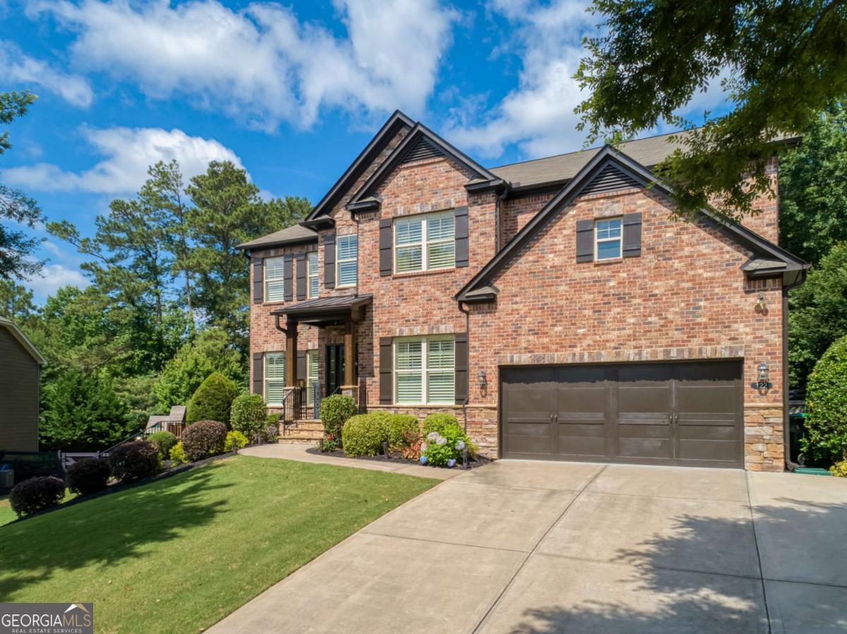 Welcome to this Upgraded and Impeccably Maintained home nestled behind the gate and tucked back in a quiet cul-de-sac, offering the perfect blend of privacy, elegance, comfort, and functionality. The finish quality here on all three levels will be hard to beat! Step inside to discover an open-concept layout filled with natural light. At the center of it all is a chef's kitchen designed to inspire. Crisp white shaker cabinets accented with oil-rubbed bronze hardware pair beautifully with warm granite counters and a striking dark-stained island - a perfect gathering place for morning coffee or evening wine with friends. Stainless steel appliances, 5-burner gas cooktop, stainless vent hood and French-door refrigerator make entertaining a joy. A herringbone tile backsplash and pot-filler faucet add both elegance and function, while glass pendant lights cast a warm glow over the workspaces. Hardwood floors tie it all together, leading seamlessly into the open family room which boasts a cozy stone fireplace and wood accent wall, creating a warm and inviting atmosphere. There is also a Main Level Guest Room, separate Dining Room AND Study. Upstairs, the owner's suite feels like its own private haven. A place to unwind in the sitting area or soak in the spa-inspired bathroom after a long day. Also features separate shower, dual vanities and ample closet space. Not to worry, there's plenty of room for everyone else to retreat and recharge. The secondary bedrooms are equally spacious and offer plenty of flexibility. The finished basement is an inviting extension of the home as main-floor quality was maintained throughout. With its spacious layout, rustic barn doors, and warm tones, it's perfect for movie nights, game tournaments, or even hosting holiday dinners in style. Outside, enjoy a private, fenced backyard that backs to trees OR ease down to the covered patio off the lower level that is perfect for watching football in the fall with a view of the cozy fire pit area. Oh, your cars will love their home too with the Guardian Garage showroom floors. This home truly has it all-inside and out!