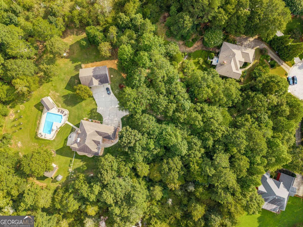Private Ranch Retreat with Pool, Full Basement Apartment & 4.63 Acres Experience luxury, comfort, and privacy in this custom 4-bedroom, 4.5-bath ranch with a full basement apartment-perfect for multigenerational living or guests. Nestled at the end of a cul-de-sac on 4.63 acres, this property blends modern upgrades with serene country charm. Step inside to soaring ceilings, new hardwood floors, and fresh paint throughout the main level. All bedrooms on the main level have their own private ensuite bathrooms, offering comfort and privacy for everyone. The recently renovated kitchen is a chef's dream, featuring leathered quartz counters, a spacious island, custom walk-in pantry, Kucht gas range, and Whirlpool appliances-all open to the inviting living room for effortless entertaining. The primary suite boasts its own office space, while the lower level offers a complete apartment for extended family or rental income potential. Enjoy peace of mind with a new tankless water heater, whole-house filtration, UV water purification system, and video surveillance with property alerts. Outdoor living is unmatched here-relax on the covered deck with pergola overlooking the fenced, L-shaped saltwater pool with a new liner and chlorinator. The pool house includes a half bath for convenience. Fruit trees, a vegetable garden, and a creek add to the natural beauty, while a custom fire pit and horseshoe area make gatherings unforgettable. Car enthusiasts and hobbyists will love the 2-car attached garage, plus a detached garage with a vehicle lift, workshop, and room for multiple cars. A garden shed, new 6" gutters, and a fenced front yard complete this incredible property. Tucked away at the end of a long, winding driveway, this home offers the perfect blend of privacy, space, and modern comfort-just waiting for its next chapter.