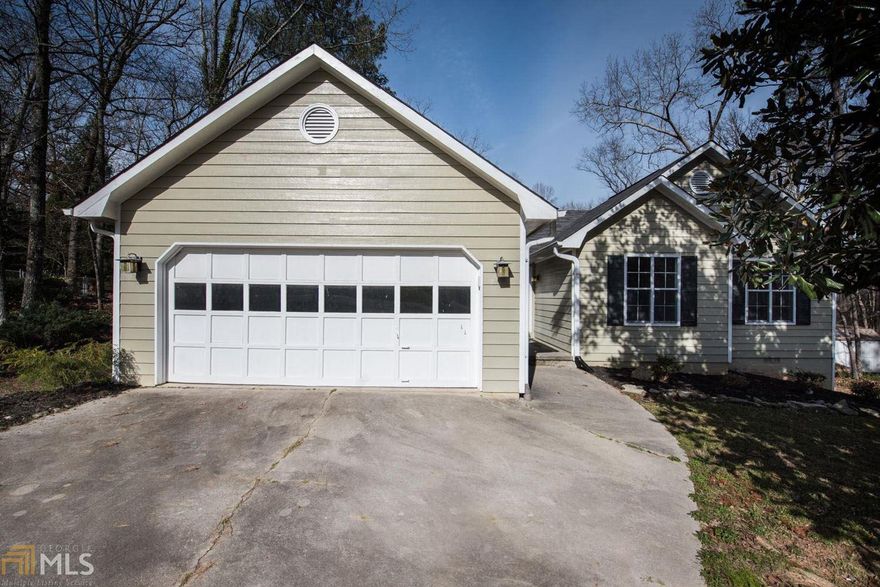 RECENTLY REFURBISHED and MOVE-IN READY! Sparkling 3BR/2BA ranch is ready for new owners. Updated light and plumbing fixtures, new paint, and new flooring throughout - hardwood in kitchen, living area and bedrooms, tile in bathrooms - no carpet! Great open plan with vaulted ceiling in kitchen/great room, double-sided brick fireplace, nice window ledge in breakfast room. Split bedroom plan. Spacious master with vaulted ceiling, bay window, large walk-in closet and bath with double vanities and separate tub and shower.  Designated mud room at entry from garage (not part of the separate laundry room). Nice oversized deck to enjoy private backyard. Fantastic 0.58 acre lot that borders vacant land in the back and on the side - sits at end of quiet street in small subdivision with no HOA.  Great location just across the Gwinnett County line.