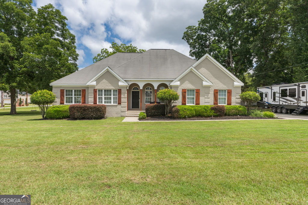 Beautifully Updated 4BR/2.5BA Home on Corner Lot with RV Hookup - Near Robins AFB This well-maintained 4-bedroom, 2.5-bath home sits on a desirable corner lot and features extensive interior updates throughout-including new lighting, fixtures, paint, cabinets, counters, and flooring. The spacious kitchen is equipped with granite countertops, double ovens, under-cabinet lighting, updated appliances, and a striking glossy wave subway tile backsplash. The living room showcases warm hardwood floors and a custom tongue-and-groove poplar wood accent wall with black walnut trim. The owner's suite offers a tray ceiling, walk-in closet, and a fully renovated bath with a freestanding soaking tub, frameless glass tile shower with glossy vertical subway surround, granite counters, and updated fixtures. Secondary bedrooms feature new carpet and share a convenient Jack-and-Jill bath, while the half bath includes a stylish shiplap accent wall. The laundry room has durable porcelain tile flooring, and a gas water heater is located in the garage. Additional features include: Hardwood floors in main living areas & owner's bedroom Updated ceramic tile in bathrooms Beadboard ceiling on the front porch Ceiling fans and blinds throughout Screened back porch, front porch, irrigation system & gutters 2 sides brick / 2 sides vinyl siding for low maintenance 50-amp RV hookup New HVAC (2023) Move-in ready and just minutes from Robins AFB!
