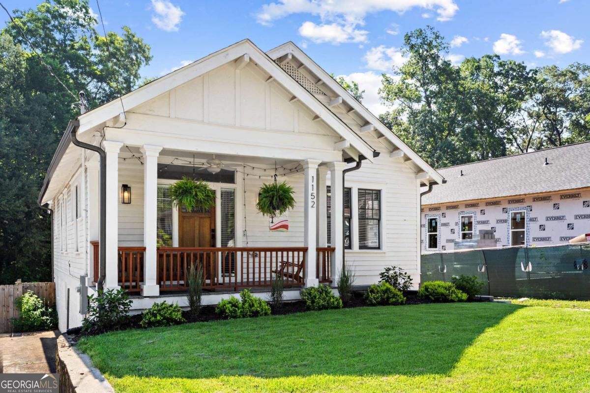 Welcome to 1152 Oakland Drive an impeccably renovated 1922 Craftsman bungalow that blends timeless architectural character with thoughtfully updated interiors, all in one of Atlanta's most rapidly growing neighborhoods. Step onto the welcoming covered front porch and through the original-style Craftsman door, framed by sidelight and transom windows, into a bright and airy living space. The main living area showcases warm hardwood floors, neutral designer paint, and striking exposed wood ceiling beams that anchor the space in historic charm. The kitchen is a true centerpiece designed for both everyday function and stylish entertaining. It features a spacious center island with bar seating, stainless steel appliances, white shaker cabinetry, sleek hardware, contemporary lighting, and an abundance of natural light. An open-concept dining area sits just off the kitchen, perfect for hosting or casual family meals. Toward the back of the home, you'll find a full guest bath, a dedicated laundry area, and access to the expansive backyard through a private rear entry. The primary suite offers a peaceful retreat with double closets, oversized windows, and a spa-like en suite bath featuring marble tile, dual quartz vanities with a custom linen tower, a glass-enclosed shower, and a private water closet. Two additional bedrooms offer flexibility for guest space, a home office, or creative use, all filled with natural light. A daylight basement provides generous storage and exterior access, while a private driveway in the rear allows for convenient off-street parking. Located just minutes from the Atlanta BeltLine, Lee + White (home to staples like Monday Night Garage, Boxcar, Hop City, and ASW Distillery), and green spaces like Perkerson Park and Rose Circle Park, this home offers unbeatable access to breweries, food halls, and vibrant community amenities. You're also close to both the Oakland City and West End MARTA stations, making commuting a breeze. Move-in ready and ideally positioned in one of Atlanta's most exciting intown neighborhoods, 1152 Oakland Drive is a perfect blend of history, comfort, and location.