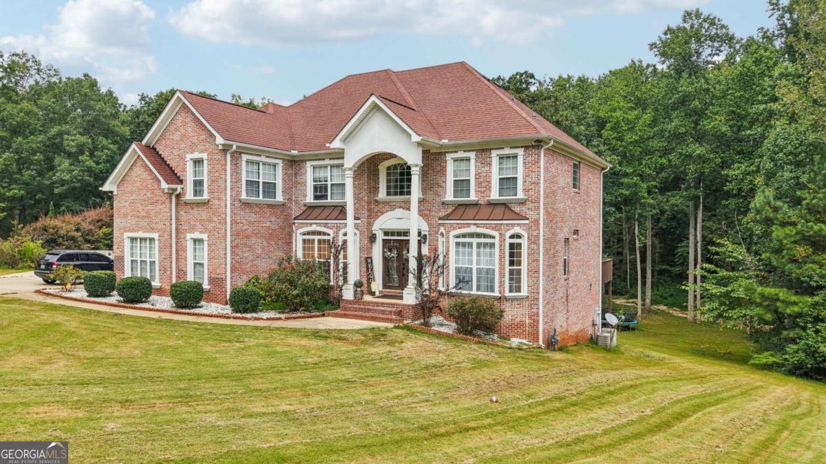 Situated on a 1 ACRE lot in a quiet CUL-DE-SAC, this beautiful three-sided brick home on a FULL FINISHED BASEMENT offers timeless curb appeal, abundant living space, and amenities that include a resort style pool and tennis courts. With a three-car side-entry garage, extended parking pad, and spacious driveway complete with a basketball hoop, this home provides both elegance and function for everyday living. Professional landscaping, a sprawling lawn, and a covered double-door entry set the tone for what's inside. Step into the two-story foyer, where hardwoods and crown molding flow into a formal dining room with wainscoting and a formal living room (or home office), both highlighted by charming bay windows. The heart of the home is the two-story family room, boasting a wall of palladium windows, a striking stone fireplace, and an abundance of natural light. The chef's kitchen is equally impressive with stainless steel appliances including a double wall oven, tile backsplash, breakfast bar, center island, and plenty of counter space. From here, enjoy direct access to the deck for seamless indoor-outdoor living. A main-level en-suite bedroom with full bath access is perfect for guests. Upstairs, the primary suite is a true retreat featuring double tray ceilings, a cozy fireplace, French doors leading to a private deck, an expansive walk-in closet plus two additional closets, and a luxurious bath with a jetted tub, double vanity, and frame-less shower with a rainfall shower head. Three additional bedrooms share a well-appointed Jack-and-Jill bath. The full finished basement offers incredible flexibility with sleek marble-like tile floors, full bathroom, multiple bonus areas for a billiards area, media room, or second living space, with two potential bedrooms. With walk-out access to the backyard, this level could easily be extended with a patio for the perfect private apartment or in-law suite setup. Outdoors, enjoy wooded views, a tranquil creek bank, and a spacious yard with a fire pit, perfect for gatherings. Stairs from the main-level deck make the backyard easily accessible for entertaining or relaxing. Just outside the hustle and bustle while still being conveniently located near schools, major highways for an easy commute, park and recreational facilities, as well as grocery option. This home combines classic style, functional design, and a prime location, making it an opportunity you won't want to miss!