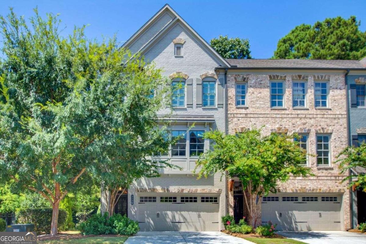 Welcome to this exquisite end-unit townhome in the coveted Skyland Brookhaven community. This meticulously maintained home has tons of upgrades throughout and functions like a Smart Home. Step inside to discover a true 4-bedroom home, where elegance meets functionality. You are greeted with beautiful hardwood floors, custom lighting from South Africa and bedroom with large custom closet, currently used as a gym. A newer full bathroom completes this level. Walk outside to your private green space as well as enjoy the community green space right outside your door. The main level is perfect for entertaining. With a high-end kitchen which features a newer walk-in pantry with custom shelving and bar,  stainless steel appliances, and a massive island perfect for hosting gatherings. The open-concept main floor seamlessly connects to a spacious dining room designed to seat 12, complete with a built-in sideboard. The generous living room offers a beautiful view of the private green space and is highlighted by built-in shelves, a gas fireplace with newer surround tile, and direct access to your private deck. This outdoor oasis includes a built-in oversized umbrella, custom planters, and fountain, ideal for relaxation and entertaining. An updated half bathroom completes this level. Head to the upper level where you will find the primary suite which features a custom walk-in closet with a 360-degree shoe holder, and an ensuite bathroom equipped with a garden tub, a separate glass-enclosed shower, and double sinks. Two additional guest rooms and a guest bathroom with an upgraded glass shower door, and updated walk-in laundry room complete this level.  Tons of additional storage throughout. This home functions like a smart home with NEST thermostats, automated voice activated window shades in kitchen & primary bedroom, fans w/light voice activation, Touch2O Technology kitchen faucet, smart front door lock & EV connection in garage. Enjoy the many community amenities- and Skyland Park. This home is one of a kind and a must see!