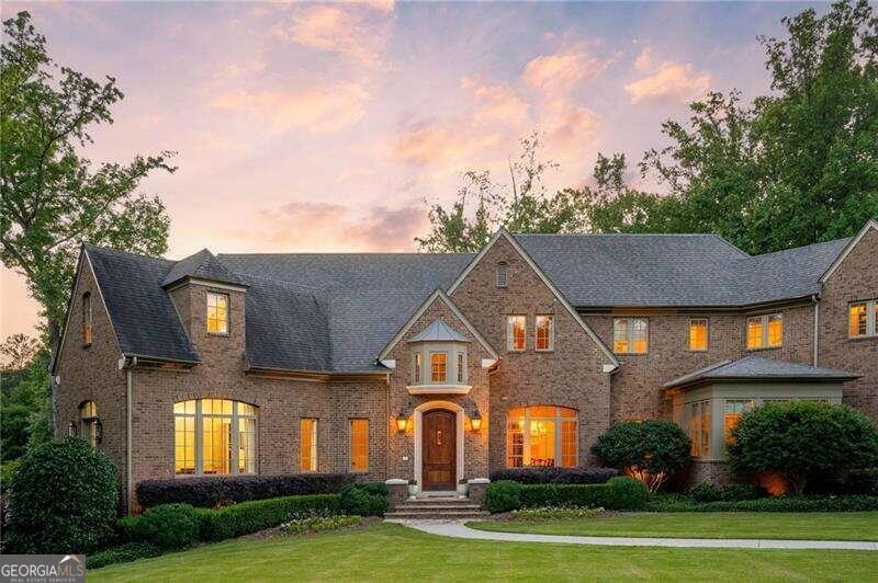 Framed by a canopy of mature trees, this stunning Harrison Design newer construction home dazzles with a refined sense of luxury and understated elegance and is situated on over 2 acres of private land. The spectacular 2-story foyer sets a tone of subtle sophistication with a dramatic curved staircase and elegant arched doorways leading to the bright and spacious great room with a wall of French doors that open to one of several outdoor living spaces. Designed for everything from large scale parties to the flow of everyday life, the stunning kitchen features custom cabinetry, stone counters and back splash, a suite of premium appliances and a large center island overlooking the cozy fireside keeping room with access to a covered patio, outdoor fireplace and gorgeous infinity-edge pool. The main level primary suite creates a welcome sanctuary with a cozy sitting area, morning bar, fireplace and private balcony along with two separate walk-in closets and a luxurious bathroom with dual vanities, walk-in shower and separate soaking tub. The upper level boasts four spacious ensuite bedrooms and convenient laundry room. Finished to perfection, the daylight terrace level has 12-foot ceilings and provides additional living and entertaining zones including a 10-seat theatre room/golf simulator, home gym with sauna and steam shower, hair salon, oversized game room and private guest suite. 2 flat play yards and fire pit area, 4 car garage. Truly a perfect 10!