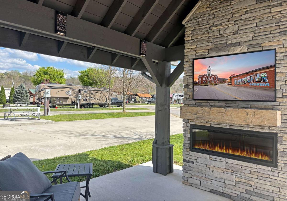 Discover the ultimate outdoor oasis with this exceptional lot that promises an unparalleled RV lifestyle! Envision your retreat with many conveniences finished for you: completed concrete work, with water and power lines already in place. This property features a versatile, insulated shed, perfect for storing your golf cart or creating a cozy retreat for the kids. There's more... At the heart of this lot is a stunning pavilion, designed with style and functionality in mind and elegant lighting that sets the perfect mood for evening gatherings. Picture yourself unwinding by the beautifully crafted stacked stone fireplace, watching your favorite shows on the TV while soaking in the breathtaking mountain views. But that's not all! The owner has thoughtfully prepared a space for a bar area, with cabinets and countertops ready for installation. For an additional $10,000, you can add custom cabinetry and countertops before closing, making this space ideal for entertaining or relaxing with friends and family. This is not just a lot; it's part of the RV lifestyle waiting to be embraced at our mountain destination in Blairsville, Georgia. Don't miss your chance to own the most astonishing lot on the block-where memories are made and tranquility reigns supreme! The property is nestled within the picturesque Georgia Mountains at Crossing Creeks RV Resort and Spa, a luxurious retreat on over 60+ acres of beautiful landscape. Immerse yourself in nature's tranquility, surrounded by the beauty of Coosa and Anderson Creeks. This lot is more than just a property; it's an invitation to embrace a serene lifestyle in one of North Georgia's finest RV communities. Enjoy amenities such as a fitness center, pools, a dog park, Pickleball courts, a community center, and much more. Your dream getaway awaits!