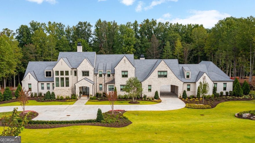 Unparalleled English Country Manor built by Smith & Kennedy nestled on 3 acres in exclusive gated Rivers Edge Milton! Timeless open floor plan featuring 6br 7ba 2hb, 10 car garage with motor court, smart technology automated control4 system, two offices on main level and elevator servicing all three levels! Grand entryway leads into massive great room with soaring 20ft ceilings, fireplace and wall of windows overflowing with natural light. Owners suite on main, private spa like bathroom with his and hers walk-in closets, his and hers bathrooms, stunning frameless glass shower with soaking tub, 11ft ceilings throughout main level. Gorgeous designer kitchen with wolf & sub-zero appliances, quartz countertops, oversized island, wooden beams, custom inset cabinetry and back catering kitchen ideal for entertaining. Porte cochere entrance leading into mudroom and one of a kind task room! Cozy family room with vaulted ceilings, dual custom sliding glass doors and fireplace. Expansive outdoor living area with stack stone fireplace, dining area, outdoor kitchen with grill, pizza oven, griddle, undercounter refrigerator and oversized island. Lush private backyard oasis featuring heated salt water pebble tec pool with raised spa and bocce ball court. Second level offers four large en-suite bedrooms, loft, additional laundry room, yoga room and 10ft ceilings throughout. Private entrance in-law suite with full bathroom and sitting area above garage. Terrace level features pub style wet bar, billiards/card room, home theatre, fitness center with full bath and sauna, ample unfinished storage space and 11ft ceilings throughout.