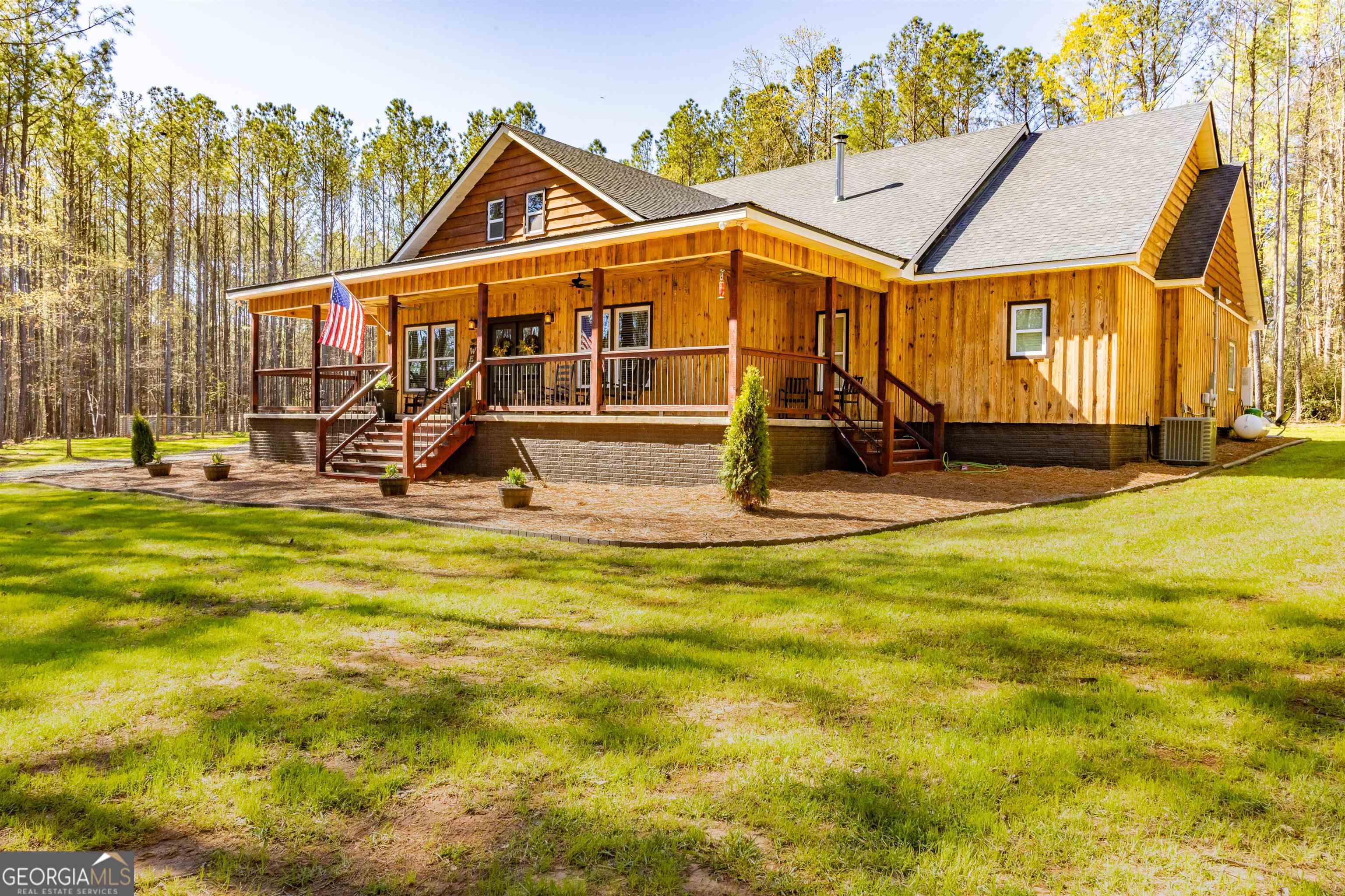 **5 acres with custom built barn!** This INCREDIBLE, custom built, LIKE NEW craftsman home has all the GORGEOUS detail you've been searching for and SO MUCH MORE! The vaulted ceilings in the living room are covered with beautiful tin, and the stone fireplace gives a grand feel to the entire room. With custom cabinets, quartz and butcherblock countertops, and brand-new stainless-steel appliances, the BEAUTIFUL kitchen opens into the large living and dining room. Matching custom cabinets continue into the separate wet bar. The owner spared no expense with this modern, luxurious home. There is a tankless water heater to heat the entire house and an additional tankless water heater just for the kitchen sink. This new home is modern while also having a sought-after rustic, farmhouse feel. In the owner's suite, you will find a large bedroom with a tastefully decorated bathroom complete with a beautiful tile shower and a large, freestanding bathtub. The HUGE owner's closet is as big as a bedroom! Also on the main floor, you will find another bedroom, a full bathroom, a beautiful half bath, and a large closet that has been reinforced to be a storm shelter. Upstairs, there is an additional bedroom and additional space to add two more bedrooms and a bathroom. Outside, the lovely, wrap-around front porch STUNS with incredible woodwork, producing loads of curb appeal and creating the perfect covered area to enjoy the beautiful southern days. There is plenty of storage between the attached garage and the carport. The outdoor kitchen and pergola are added touches that make this luxurious home even more special. No detail was overlooked and no expense was spared with this UNBELIEVABLE custom home! Call today to schedule a private showing!