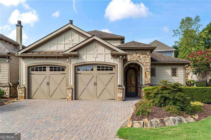 This home is the one everyone wishes they could live in! It's an Earthcraft certified European-style courtyard home located on a beautiful cul-de-sac lot, designed to maximize both outdoor and indoor living spaces. The property features stunning architectural details, including 10-foot ceilings with triple crown molding, 12-inch baseboards, 8-foot radius doors, and arched doorways. You'll love the surround sound system installed in the great room, the owner's suite and courtyard. The dining room, great room & guest bedroom all open to a gorgeous courtyard, which is one of the largest in the community. The chef's kitchen boasts beautiful stainless steel appliances, granite countertops, a custom pantry, pendant lighting, a 6-burner gas stove, tile backsplash and under and over-cabinet lighting. The spacious owner's suite features a lovely sitting area, and a luxurious bathroom with a tiled walk-in shower, dual vanities, and a custom closet. Both the owner's suite and an additional bedroom are located on the main level, each offering beautiful views of the outdoor living area. Upstairs, two additional bedrooms share a Jack & Jill bath. Additional features of this home include a central vacuum system, multiple HVAC units, natural gas line hookup for your grill, a security system with a phone app, Low-E windows, a Rinnai tankless water heater and foam insulation for low energy bills. The 2-car garage has an epoxy -finished floor and a utility sink. The community offers country club amenities, including a stunning clubhouse, fitness center, billiards room, indoor & outdoor fireplaces, an oversized swimming pool, pickleball courts, bocce ball courts and 3 dog parks. The homeowner's association maintains the front yard lawn and landscaping. This upscale community is just minutes from the charming downtown Woodstock, shopping, restaurants, the Greenprints trail system, and I-575.