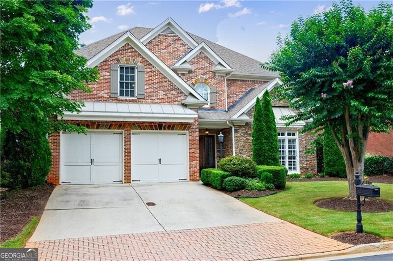 Carefree Living in a Gated Manor Home Community! Enjoy the ease of low-maintenance living in this beautifully maintained four-sided brick home, ideally located in a private, gated enclave. The homeowners association takes care of both the front and rear yard maintenance and includes weekly trash service-giving you more time to relax and enjoy your home. Step inside the elegant two-story foyer and discover a bright, open floor plan designed for both comfortable living and effortless entertaining. The light-filled dining room sets the stage for everything from formal dinners to casual gatherings. The spacious Great Room features a cozy stone fireplace flanked by custom built-ins, flowing seamlessly into the heart of the home: a chef's kitchen equipped with granite countertops, a gas cooktop, double ovens, a pantry, refrigerator, and a convenient Butler's Pantry. The adjoining Keeping Room with its second fireplace and French doors opens to a private patio and fenced backyard-perfect for quiet mornings or evening get-togethers. The main-level primary suite offers a peaceful retreat with garden views, a spa-inspired bath with double vanities, whirlpool tub, and a custom walk-in closet. Upstairs, you'll find three generously sized bedrooms-one with an en-suite bath, two sharing an adjoining bath-along with a versatile loft space ideal for a home office, fitness room, or media lounge. Additional highlights include a main-level laundry room (washer and dryer included), plantation shutters throughout, and a private backyard oasis. Unbeatable location just minutes from GA 400, Avalon, North Point, and downtown Alpharetta-with Newtown Park just a short walk away. Lightly lived in and move-in ready, this home offers the perfect blend of comfort, convenience, and community.