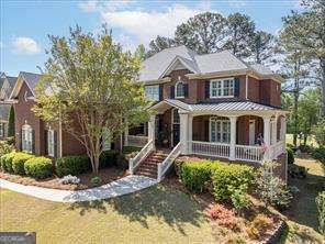 Welcome to The Oaks at Apalachee Farms, a prestigious golf, swim, tennis, and pickleball community known for upscale living and resort-style amenities. This one-owner, meticulously maintained 5-bedroom, 4.5-bath custom home is gracefully positioned on the 8th green of the acclaimed Trophy Club of Apalachee Golf Course, offering panoramic fairway views and timeless Southern elegance. From the moment you arrive, the stately brick facade and professionally landscaped grounds set the tone for refined living. Inside, the home boasts an expansive floor plan filled with natural light, including a chef's kitchen featuring a generous center island, breakfast area, and an inviting keeping room-perfect for casual gatherings or morning coffee. The two-story great room is a showstopper, anchored by a wall of soaring windows overlooking the golf course and spacious enough to showcase a baby grand piano. Plantation shutters have been thoughtfully added throughout the home, enhancing both style and privacy. The main level features a private guest suite with an en-suite bath and a spacious three-car side-entry garage. Upstairs, retreat to the oversized primary suite complete with a whirlpool soaking tub, separate glass-enclosed shower, and dual vanities. Two additional bedrooms also offer private en-suite baths, while the fifth bedroom is currently configured as a custom media room, complete with projector and screen-ideal for movie nights or game day entertaining. The full, walk-out daylight basement is framed and ready to finish, offering endless potential for a custom wine cellar, home gym, in-law suite, or entertainment space. Community amenities include 7 lighted tennis courts with active league play, a Jr. Olympic-size pool, private adult-only pool, kiddie pool with water slide, 6 pickleball courts, a clubhouse with fitness center, and a picnic pavilion. Optional golf memberships are available at the Trophy Club, making this a dream home for golf and sports enthusiasts alike. Located just minutes from I-85, the Mall of Georgia, Coolray Field (home of the Gwinnett Stripers), and top-rated Hebron Christian Academy, this property offers both lifestyle and location.