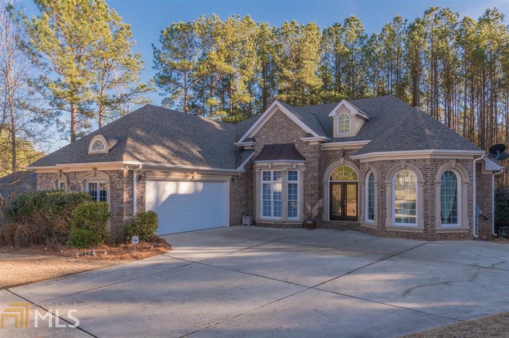 A truly charming all brick 6 bed, 4.5 bath ranch house with finished basement (total heated area 5605 SQFT) is in the ever-desirable Boulder Springs with sought-after Oconee County schools, 2 swimming pools and tennis courts, a club house, miles of trails, and stocked pond. NEW (November 2020) ARCHITECTURAL SHINGLE ROOF with 5 yr warranty! The home is tastefully designed, with large picturesque windows, the open floorplan with high vaulted ceilings, 3 fireplaces, 2 large living spaces, and cozy den area. FRESHLY PAINTED in July 2020! The main level opens with boasting beautiful hardwood floors, a bay window dining room on the left and a beautiful room with a bay window on the right. The Master Suite is on the main floor, with a sitting area, large windows and a beautiful trey ceilings, a large luxurious bathroom with soaking jetted tub and separated tiled steam shower cabin and two walk-in closets. Jack-and-Jill bedrooms on main with a full bathroom and closets. The kitchen features granite countertop, wet bar, backsplash, stainless steel appliances, and a big pantry. There is en suite bedroom on the top level with full bathroom and a large finished bonus room. The fully finished basement impresses immediately with its custom design! Professionally equipped home movie theater with built-in stereo speakers throughout the crown mold ceiling, retractable screen, HD projector, fireplace, granite bar, office/studio and bedroom with a walkout exit, full bath, glossy wet look floor, tons of storage and access into a cozy patio under deck with the newly installed ceiling. The large deck overlooking a private backyard to enjoy beautiful view of pines sticking up. 5 minutes from Watkinsville,15 min from UGA and Athens.