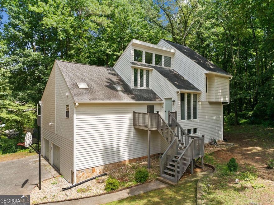 Exceptional in the Highly Desired Lashley Farms Neighborhood, close to all that East Cobb has to offer and minutes to Shopping and Dining. This private retreat is situated perfectly in the neighborhood with an Expansive Open Floor Pan. Newly Painted Exterior Welcome you as you Enter the Two Story Foyer in this Immaculate home w/ Freshly Painted Interior and Beautifully Renovated. Sunny & Bright Chef's Kitchen w/ White Kitchen Cabinets w/ Plenty of Pull-Out Shelving, Granite Counters, Island, Updated Lighting Fixtures, Gas Range w/ Vent hood, Tiled Backsplash & Pantry w/ Views to the Family Room & Views to the Private Backyard. Family Room with Stone Fireplace Overlooks Yard w/ Two Decks! The Formal Dining Room w/ Large windows offers plenty of Natural Light & is perfect for Entertaining. Powder Room w/ Updated Vanity, Faucet & Light Fixture. Upstairs Enjoy the Massive Owners Suite w/ Vaulted Ceiling, Walk-In Closet & the Owner's Suite Bath w/ Updated Luxury Vinyl Floor, Oversized Vanity w/ Dual Sinks, Free Standing Tub & Separate Tiled Shower! Master Suite w/ Private Deck. Two Secondary Bedrooms Upstairs Share the Updated Secondary Bath. Loft Space Upstairs. Finished Basement w/ Bar, Family Room w/ Fireplace & Built ins & Fourth Bedroom w/ Bathroom.  Additional Storage in the Basement & Garage.  Private & Wooded Backyard is the perfect space to relax. This home is located minutes to private schools Mt. Bethel, East Cobb & Top Rated Public Schools. Upgrades include New HVAC (Upstairs) - 2025. New HVAC (Main) - 2023 w/ Lenox S40 Smart Thermostat. New Paint (Interior & Exterior) - 2025. New Luxury Vinyl Flooring (Kitchen & Master Bath & Basement Bath) - 2025. All New Light Fixtures - 2025.  All New Plumbing Fixtures - 2025. Roof - 2019.