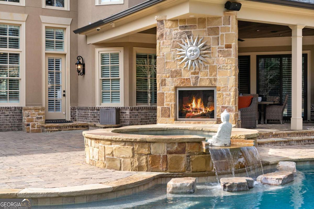Experience the pinnacle of luxury living in this magnificent estate, overlooking the 11th Green in the highly sought-after gated community of The Manor Golf & Country Club-one of the most exclusive enclaves in the Southeast with world-class amenities, exceptional privacy, and unparalleled prestige. This exceptional property offers over 10,000 square feet of refined living space, masterfully designed for elegance and comfort. This dream home includes five oversized bedrooms, with the potential to add a sixth, ensuring ample space for family and guests. From the moment you enter, you'll be captivated by the exquisite craftsmanship and thoughtful details throughout. Gleaming upgraded one-and-a-half-inch-thick hardwood floors span the entire residence, exuding timeless sophistication. A striking circular staircase greets you in the grand foyer, setting the tone for the opulence that awaits. An elevator effortlessly connects all levels, ensuring ease of access. The estate boasts a wealth of luxurious amenities to elevate your lifestyle. A full, state-of-the-art gym is perfect for fitness enthusiasts, while the massage room on the upper level provides a tranquil retreat. For evenings of entertainment, indulge in the dedicated movie theater, complete with a dry bar for an elevated cinematic experience. A stunning wine cellar on the main level, crafted with luxurious stone, is the perfect space to showcase your wine collection. The gourmet kitchen is a chef's dream, featuring an oversized island, Subzero refrigerators and freezers, Wolf range and three ovens, and an oversized walk-in pantry. Adjacent to the kitchen, the double-story great room and family room offer an impressive space for gathering and relaxation. The primary suite is conveniently located on the main level and serves as a serene retreat. The oversized office on the main level provides the perfect space to work from home in style. Custom-designed walk-in closets offer ample storage, combining functionality with elegance. The home also includes an oversized doggy spa with a large shower, two laundry rooms-one on the main and another on the upper level-and a well-appointed mudroom. The outdoor spaces are nothing short of extraordinary. The private backyard is an entertainer's paradise, featuring a sparkling pool, hot tub, outdoor kitchen, fire pit, covered patio with a fireplace, and a second outdoor kitchen. The backyard overlooks the pristine golf course, creating a serene and picturesque setting. Don't miss your chance to experience this architectural masterpiece. Schedule your private tour today and discover what makes this property truly extraordinary.