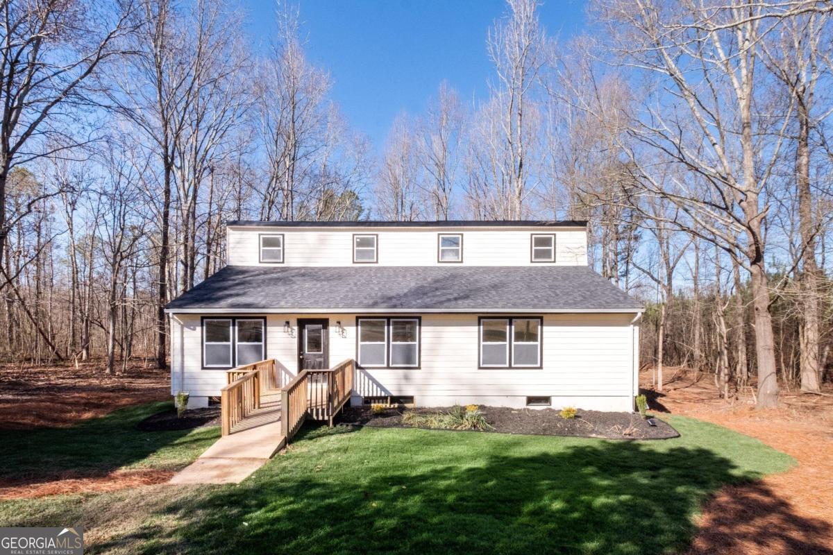 Newly Remodeled and updated! Nestled on a serene and expansive 3-acre property, this inviting residential listing presents an ideal haven for those seeking space, tranquility, and modern comforts. The hardwoods are gorgeous and is an outdoor persons paradise or a hunters dream.  At the back of the property is a small stream which large bucks have been spotted.  Boasting three generously sized bedrooms and three well-appointed bathrooms, this home offers a perfect blend of functionality and style. The interior features a thoughtfully designed floor plan, creating a seamless flow between the living spaces. The bedrooms provide comfortable retreats, while the bathrooms showcase contemporary finishes and amenities. This stylish farmhouse home is enveloped by lush greenery, ensuring privacy and a connection with nature. With three acres of land at your disposal, there's ample room for outdoor activities, gardening, or simply enjoying the peaceful surroundings. Whether you're drawn to the spacious new interior, the abundance of outdoor space, or the harmonious marriage of both, this property promises a delightful and well-balanced living experience.  This home has been fully renovated.  The new owner will have peace of mind knowing that the home has a new roof, new siding, new windows, new water heater, new back covered deck, a beautiful custom built 2-car open air carport.  The kitchen has beautiful quartz countertops, with all new stainless steel appliances. Welcome to a masterfully crafted Craftsman house, where the artistry of custom carpentry takes center stage, embodying the timeless beauty and meticulous attention to detail that defines this architectural style.  *This property is zoned agricultural and may qualify for USDA zero down loan or other special financing.  There is a double wide home at the front of the property that is that has also been remodeled that would be great for multi-families wanting to live close together. Perfect home for a small business that has vehicles/trucks, there is plenty of room and privacy to park vehicles as well as fencing in the property.