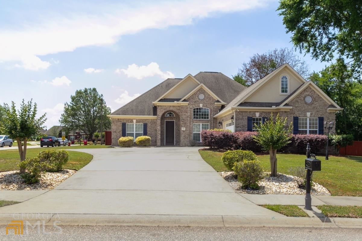 OVER HALF ACRE CORNER LOT surrounds this four sides brick beauty offering 4 bedrooms & 3.5 baths. Located in the gated community of Eagle Springs featuring community pool, tennis, fitness center, clubhouse and scenic lakes -options abound for socializing with neighbors and friends or enjoying the tranquil escape in your privacy fenced backyard offering covered back porch and open air patio with built in grill. Foyer into dining and living area all offer soaring ceilings, hardwood flooring and gas fireplace in great room. Three bedrooms and 2.5 baths downstairs with large bedroom w/full bath upstairs. Spacious owner's retreat offers trey ceilings and scenic view into your private backyard along with bath featuring double vanity, separate shower and jetted tub along with large walk-in closet. Mere minutes to schools, shopping and RAFB.