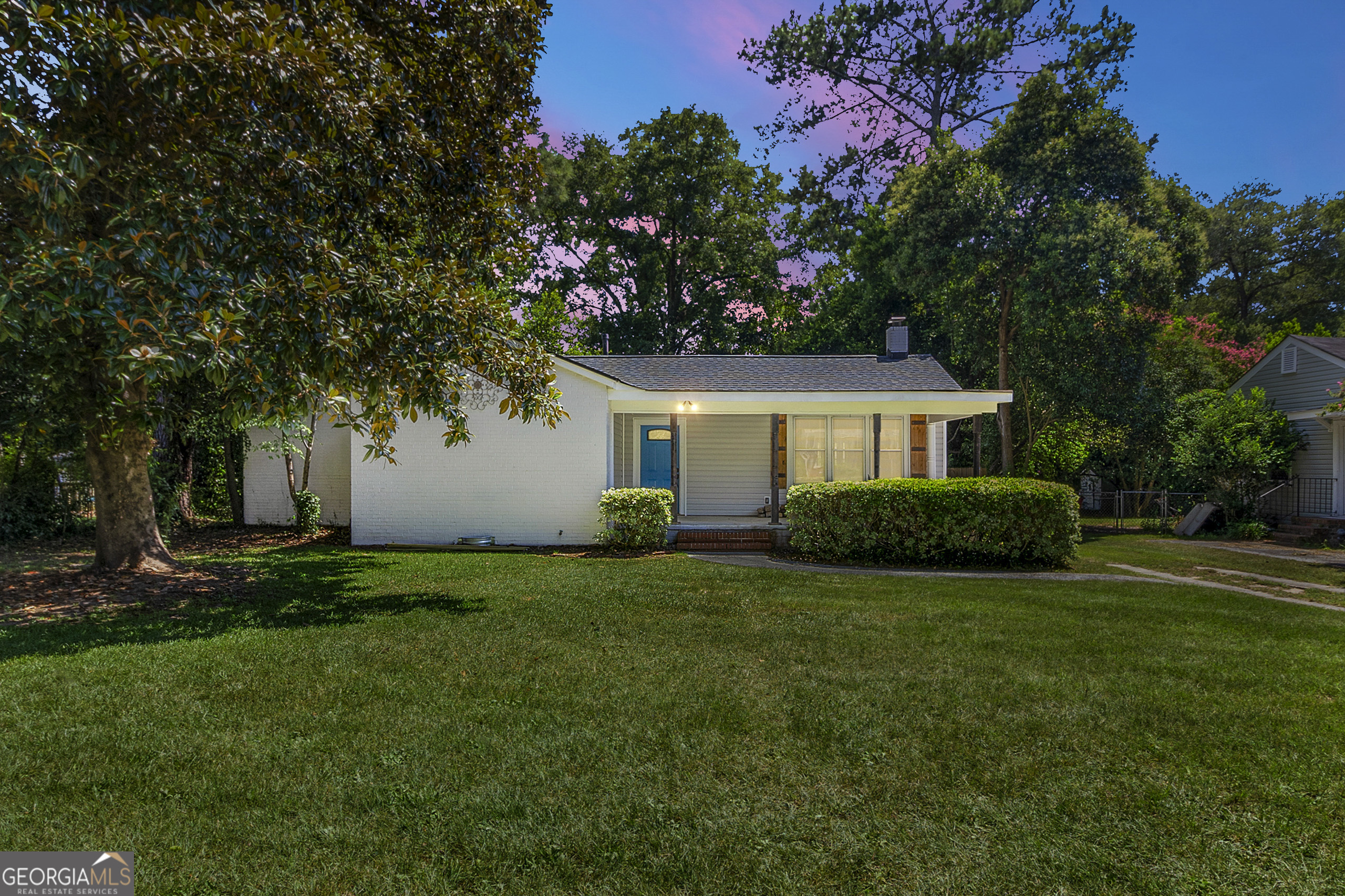What a treasure this home is! Nestled on one of the cutest, quietest, and well-maintained streets in Macon - just minutes from everything the city has to offer. Enjoy incredible curb appeal and a large, fully fenced backyard with a wooden privacy fence and a small outbuilding for extra storage or workspace. Inside, you'll find hardwood floors, fresh paint, and new blinds throughout. The open-concept living area features built-in shelving flanking a beautiful brick, wood-burning fireplace-perfect for cozy nights in. The layout includes two secondary bedrooms with a shared bath on one side of the home, and an impressively large master suite on the other, complete with additional closet and storage space. The kitchen boasts granite countertops and open-concept cabinetry, ideal for entertaining and everyday living. Relax on the large covered front porch or retreat to the private covered back porch for quiet mornings or evening gatherings. Whether you're a growing family or a retired couple looking to downsize, this sweet property is a perfect fit. Don't miss out-come see it today! Sold as-is and currently not FHA eligible.