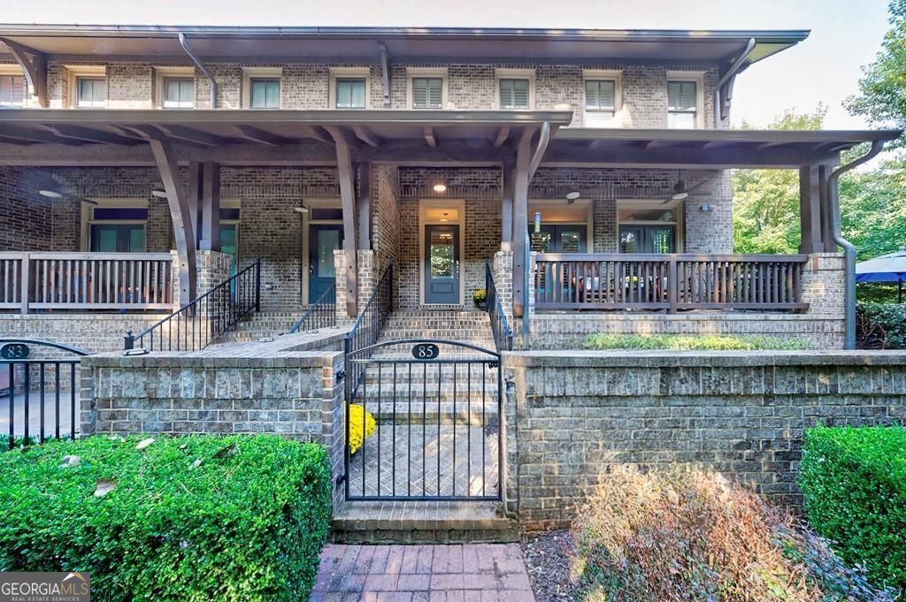 Tucked down a quaint brick path framed by trees, this stunning brownstone in the coveted Providence community redefines in-town living in Historic Roswell-just steps from the vibrant shops and restaurants of Canton Street. Enter through a charming iron gate to an expansive brick courtyard with a built-in grill, dining area, and firepit. A rocking chair front porch overlooks the lushly landscaped entry, offering both beauty and privacy. Inside, the main level boasts 10-foot ceilings, engineered hardwoods, and three elegant living spaces that live like a single-family home. A curved wall defines the spacious family room featuring a stone gas fireplace with wood mantle, built-in bookcases, and window seats. Two sets of French doors open to the front porch while side windows bathe the space in natural light. A gracious dining area easily accommodates a banquet-sized table for gatherings with family and friends. The gourmet kitchen is a true showpiece with custom cabinetry, exotic granite island, and a keeping room. Holiday entertaining is effortless with a 60" six-burner Thermador range with griddle and double ovens, a pot filler, paneled SubZero refrigerator, wine bar with cooler, and walk-in pantry. Upstairs, the primary suite retreat offers a sitting area, beverage fridge, custom walk-in closet, and spa bath with soaking tub and frameless shower. Two secondary bedrooms with large closets and a full bath complete this level. The finished terrace level adds incredible flexibility with a true theater room and serving bar, full bath, flex space for office/gym/guests, and a built-in mudroom. The home is elevator-capable for added convenience. Providence offers pocket parks, an outdoor pavilion with fireplace, and a dog park-all just steps from Roswell's dining, shopping, coffee shops, and festivals. 85 Webb Street is a stunning retreat in the heart of it all. Love Where You Live!