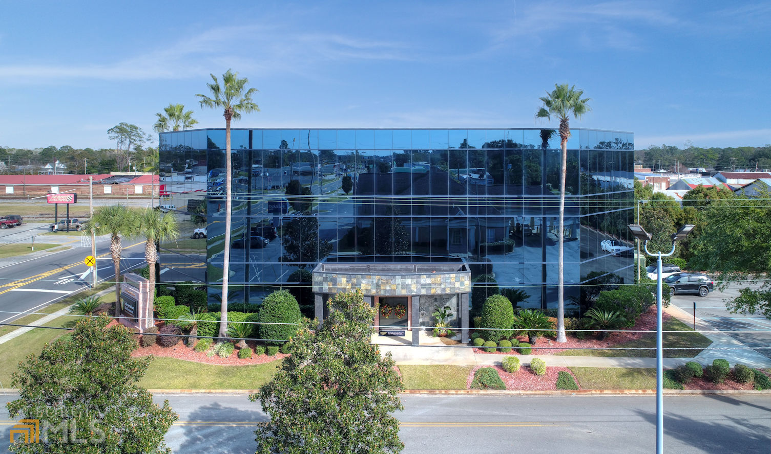 Beautiful black glass three story professional building for sale. Located only 39 miles north of Florida line just off I-75. This building would be perfect for logistics company, medical facility, or corporate office. Truly one of the most impressive structures in South Georgia. Building is 19,827 square feet with marble foyer, brass elevator, huge executive conference room, large meeting room with full technology, multiple private furnished offices, and two executive office suites with private full baths. Inside of building, especially second floor can be configured in many different ways to suit new owner. Entire facility has custom bathrooms, and breakrooms with kitchens on each floor. New roof has ten-year warranty. Paved parking lot has 80 spaces. Asking price is well below what it would cost to build today. Please call for an appointment for private showing.