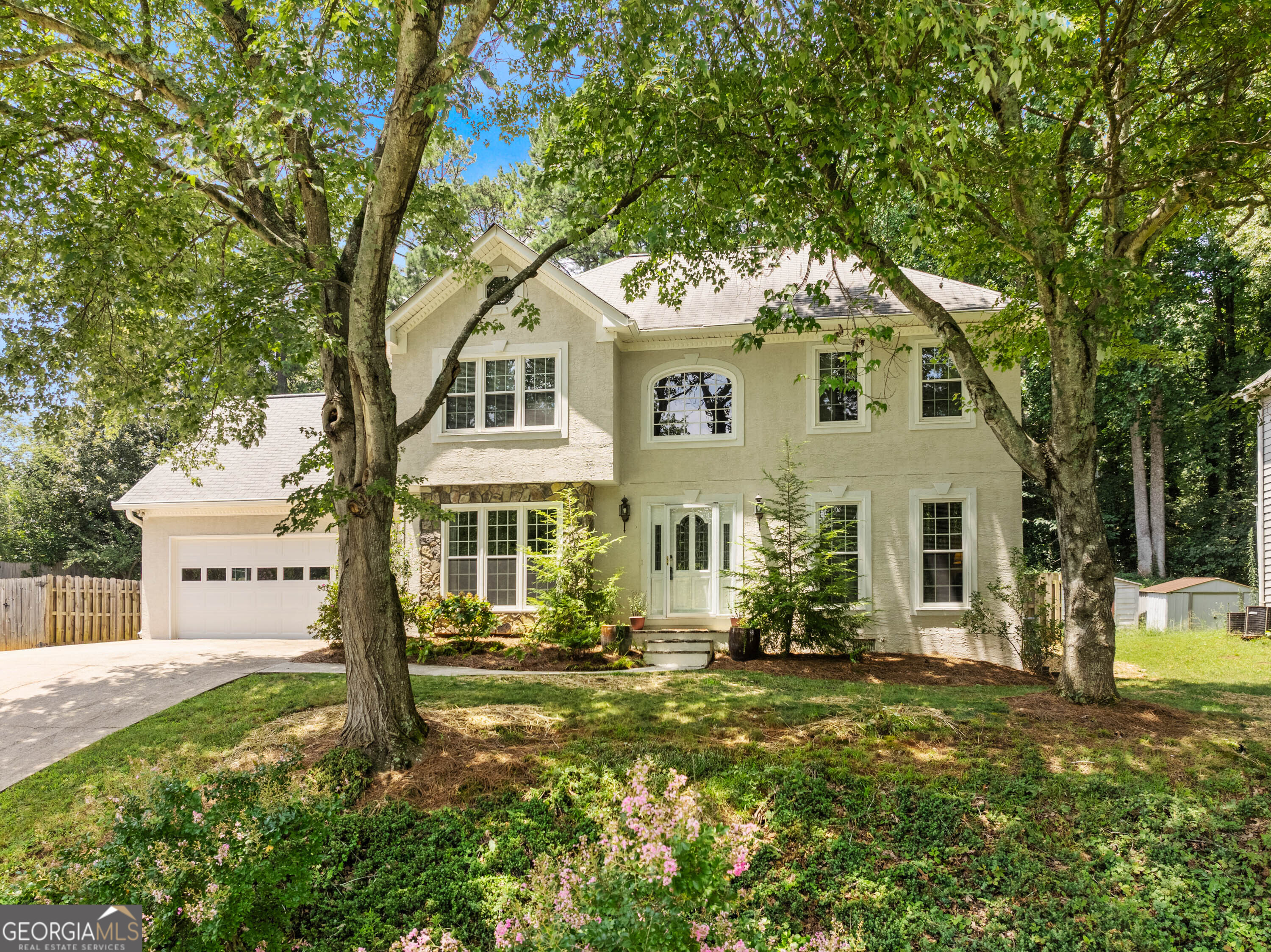 Honey, Save this as a Favorite and Let's Schedule a Showing!! Move in Ready 4 Bedroom, 2 and 1/2 Bath Beauty in Sought After Steeplechase Subdivision! Yes, we're on a hill, but wait till you see what's at the top! Lush, level, professionally landscaped (and fully fenced) back yard with patio space and a raised garden (complete with vegetables ready to harvest!). Easy maintenance hardcoat stucco, stone, and vinyl exterior. Secondary side parking pad on side of garage. Gorgeous engineered wide plank wood flooring on the main level and lush, neutral carpeting on second level. Leaded glass front door and transoms. Additional room on main level that's perfect for an office or kids playroom. Two steps from garage to kitchen for ease of unloading those groceries. Beautifully appointed kitchen design with stainless appliances, built in wine rack and granite countertops. Eat-in kitchen with a large picture window overlooking the back yard oasis. Cozy den with stone fireplace and french doors to patio.Huge master bedroom, double sinks, jacuzzi tub AND NOT 1 BUT 2 WALK IN CLOSETS! Double pane windows throughout. The back yard is complete with a rain barrel and storage shed for all your yard tools. This amenity rich neighborhood has a very active Swim/Tennis/Pickleball community and neighborhood social activities. Minutes to award winning Peachtree Ridge High School. Close proximity to Publix, Kroger, Dining, Suwanee Town Center and all it offers, Rock Springs Park, Suwanee Greenway and Gas South Arena and much more! 5 minutes from I-85. This Exceptional Home is Ready to Live In and Enjoy!