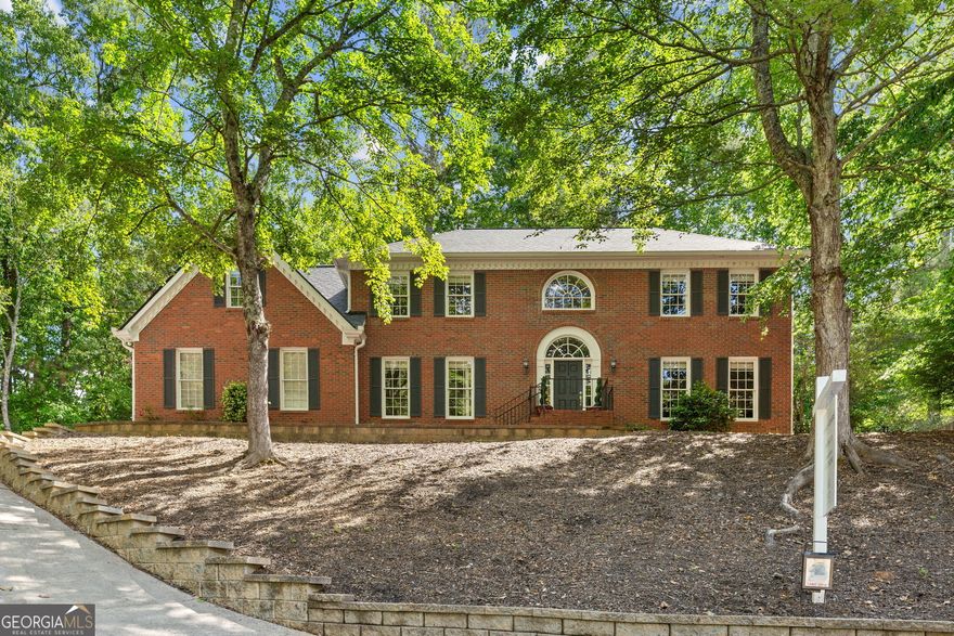 Nestled on a serene, wooded lot overlooking Hickory Ridge, in coveted Crabapple, this stunning residence offers a rare combination of privacy, charm, and a prime location. Experience the best of small-town living with every modern convenience in one of the most sought-after top rated school districts. Step inside to discover a home filled with character and one-of-a-kind features. The grand curved stairwell in the front hall immediately sets the tone, offering a warm and elegant welcome. Hardwood floors span both levels of the home. The spacious great room is a true standout, complete with custom built-ins, a cozy fireplace, and a stylish wet bar with adjacent separate office and living room-perfect for entertaining or unwinding after a long day. Just off the hall is a generously sized dining room, ready to host your dinner parties and celebrations. The kitchen has been renovated and blends style with functionality: stainless steel appliances, a striking granite island and countertops perfect for prep work or casual dining, and a sunny breakfast nook with peaceful views of the private backyard. The oversized primary bedroom is a true retreat with plenty of room for a sitting area or workspace, it offers comfort and flexibility. The renovated primary bath features new marble vanity, new designer soaking tub, private shower, linen closet and walk in closet with views of the private back yard. One of the home's unique features is the screened porch-a tranquil three-season haven that opens to the private, level, pool ready back yard. The full unfinished terrace is stubbed for bath and has partial HVAC and could easily be finished to your needs. This home is up a steeper driveway but the rewards of privacy and the peace and quiet you crave, all while being just moments from shopping, dining, and the energy of Crabapple, Downtown Alpharetta, Downtown Roswell, Avalon and easy access to Interstate 400 make that a plus. Don't miss this rare opportunity to own a thoughtfully designed, beautiful home in one of Milton's most beloved neighborhoods. Schedule your private tour today, and come experience what makes this home-and this community-so incredibly special.
