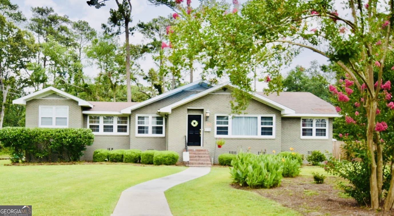 BRAND NEW ROOF! This spacious ALL BRICK property has 3 bedrooms and 2 baths, EXTRA ROOM could be 4th BEDROOM, Office, Workout space, OR PLAYROOM. The home features original HARDWOOD FLOORING adding character and warmth to the living spaces. Open and bright with natural light the kitchen has a delightful glass window box and convenient pass-through window into the dining and living areas. The additional room offers versatility for individual needs for any family. Outside is ready for enjoying the large, newly fenced yard, complete with a patio area, ideal for family gatherings and entertaining. Close to VSU, I-75, and all area restaurants/shopping.