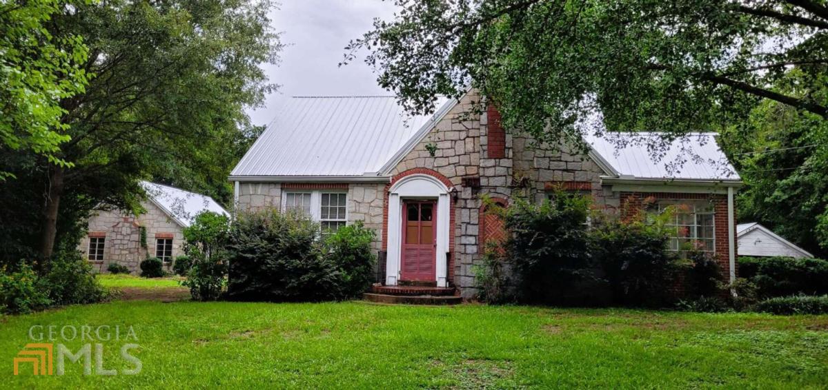 Fantastic house with a touch of history. 1.5 acres surrounded by trees. Dr. Greens stone house with separate guest house that could be made into an in-law suite. Come up to the side door of the main house and step into the sunroom. Walk into the living room that's open to the dining room and makes a great entertaining area. The living area has a wood fireplace for the cool nights and the shaded sunroom to relax in. Beautiful old hardwood floors in most rooms. The kitchens stainless steel appliances has a gas stove for the chef in the family. Granite countertops with the side counter gives extra room for preparation. There is a side door to go outside or go up the back stairs to the large floored attic that you can stand up in. Back to the hall you have 3 bedrooms with large windows, a linen closet and full bath with tile shower top. To the left is the basement. The original basement with plenty of room for storage and the washer and dryer. Outside you have a 668 SQ. FT house that can be made into a guest house or in-law suite with a little work. Side driveway from Hwy 22 goes directly to the guest house. The pecan tree shades the 1 car carport, outdoor grill and picnic area. New metal roof put on last year.