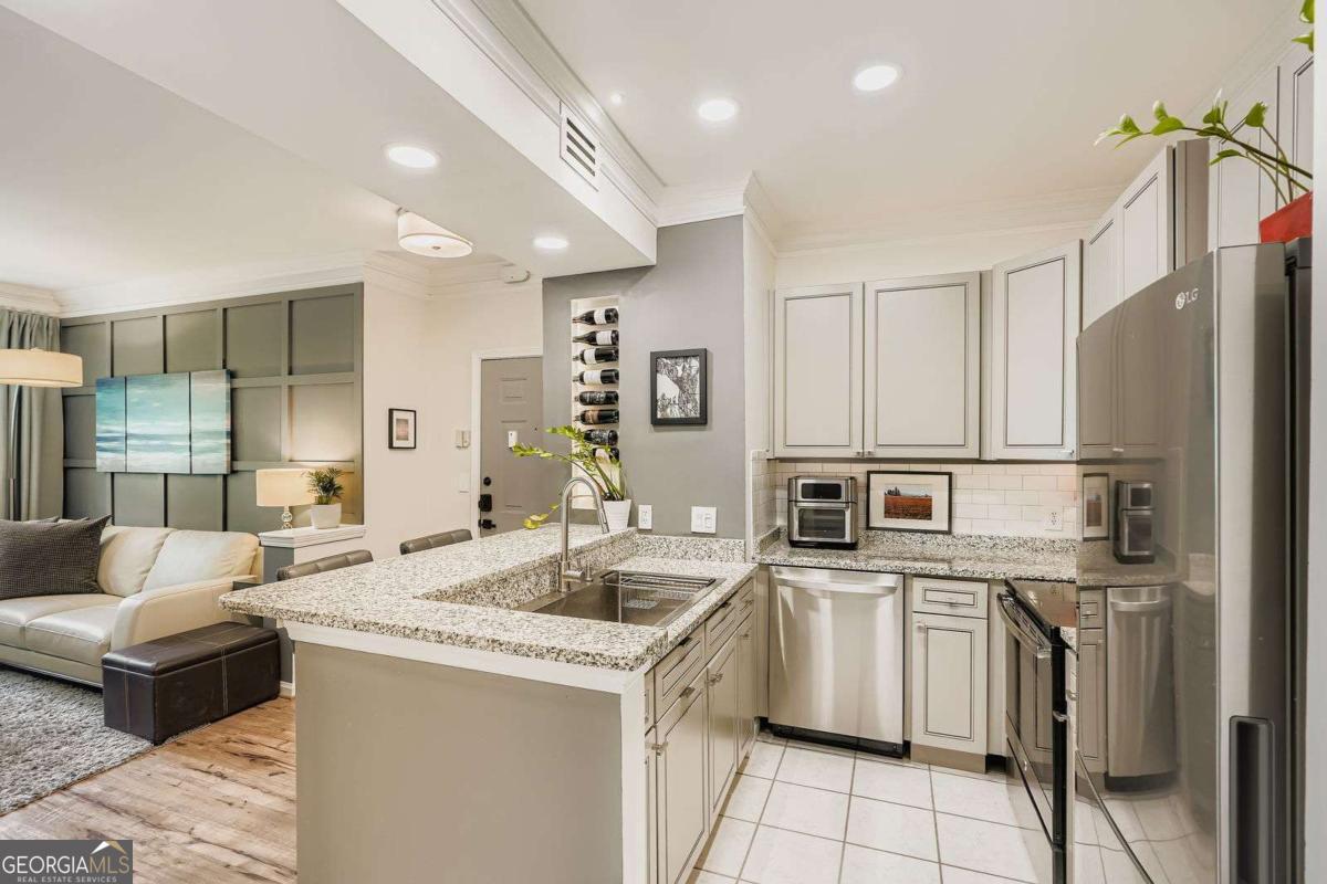 Welcome to Midtown living at its finest! This beautifully renovated top-floor home offers the perfect blend of modern sophistication, unbeatable convenience, and luxurious upgrades-all wrapped in a serene, gated community with resort-style amenities. Step inside and prepare to be impressed! This freshly painted, bright south facing home enjoys tree top views through new energy efficient sound reducing windows. The spacious updated kitchen includes sleek LG appliances, granite countertops, with modern finishes including under and above cabinet lighting. All closets and walk in laundry room feature reconfigurable shelving to maximize space. Enjoy morning coffee on your large private balcony perched high above the quiet side street. The large tranquil primary suite is a dream with an oversized closet with custom shelving and through the pocket door awaits your large bathroom with updated finishes. This is your modern, high tech home with all lighting is on dimmable smart switches so you can set the perfect mood, stay comfortable with an Ecobee thermostat, and stay secure with a Ring doorbell camera, and Yale smart lock. A new HVAC system ensures year-round worry- free comfort. Beyond the beauty inside, this home includes a deeded garage parking and is part of a charming, community featuring lush courtyards and a sparkling swimming pool-a true urban oasis! A new 50-year tile roof was installed in 2021. And let's talk about LOCATION. Nestled in the heart of Midtown, you're just steps from Piedmont Park, the vibrant business district, and the Emory/Crawford Long corridor. With MARTA rail access, top-tier dining, buzzing nightlife, and major job centers at your doorstep, this is city living at its best. Opportunities like this don't last! Schedule your private tour today and step into the Midtown lifestyle you've been dreaming of!
