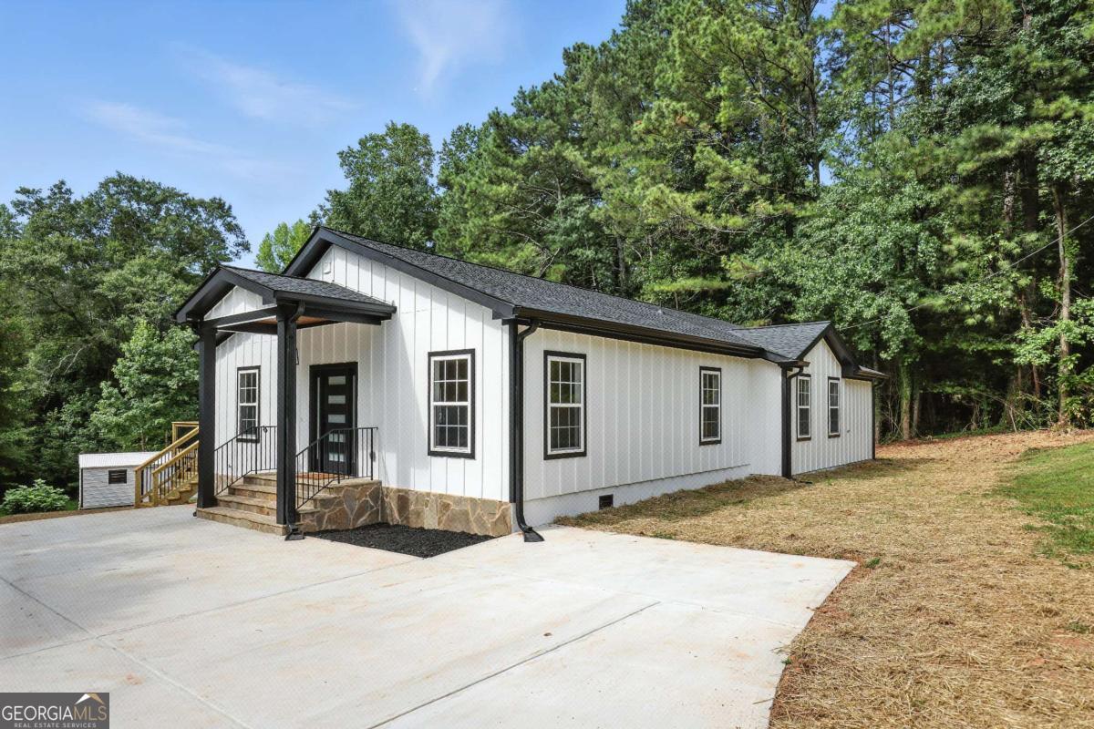 A newly built modern farmhouse on 1.27 acres with no HOA, just minutes from Milton, Alpharetta, and Canton. This one-level ranch blends clean design with peaceful, easy living. Inside, the open layout feels bright and airy with wide-plank hardwood floors, recessed lighting, and a seamless flow from the living room to the designer kitchen, where quartz countertops, stainless appliances, and custom cabinetry make everyday living and entertaining a breeze. The oversized back deck invites morning coffee with wooded views or quiet evenings under the stars. The spacious owner's suite features a large walk-in closet and a beautifully tiled bathroom with walk-in shower and matte black fixtures. A generous backyard, storage shed, and flat front lawn offer plenty of space to play, garden, or simply unwind. Whether you're upsizing, downsizing, or looking for a fresh start, this home delivers comfort, charm, and room to breathe.
