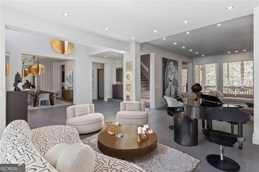 A true architectural marvel, this home was meticulously curated by the internationally acclaimed Faytak Designs, founded by visionary designer Faye Takaloo. Since 2009, Faytak Designs has set the gold standard for opulent living, transforming elite spaces across Atlanta, Los Angeles, London, and Dubai into breathtaking sanctuaries where elegance meets functionality. Now, that same level of world-class sophistication graces this exceptional residence. Step through custom double iron doors into a stunning foyer where sleek gray porcelain slabs and an awe-inspiring Italian chandelier immediately set the tone for refined elegance. Straight ahead, a sculptural staircase-a work of art in itself-ascends gracefully, while a curated art installation at its base adds a touch of intrigue. To your left, the dining room dazzles with a sophisticated mirrored and wood-paneled accent wall that blends glamour with warmth, creating the perfect setting for memorable gatherings. The original family and living rooms have been seamlessly combined into an expansive entertainer's dream, where form and function harmonize effortlessly. Anchoring this impressive space is a crocodile-motif Fendi piano-a statement piece that exudes opulence. Thoughtfully curated decor and avant-garde design elements elevate the atmosphere, making this home as livable as it is visually stunning. The heart of the home, the kitchen, is a culinary masterpiece where no detail has been overlooked. Custom soft-close cabinetry, pristine quartz countertops, and top-of-the-line appliances, including a Sub-Zero-style cabinet-front refrigerator, double French ovens, and a 6-burner Viking gas cooktop with a pasta faucet, ensure that this space is as functional as it is breathtaking. Whether hosting intimate dinners or grand celebrations, this kitchen delivers a seamless blend of elegance and utility. On the main level, a generously sized guest suite offers the perfect retreat, complete with an updated ensuite bath-ideal for visiting family or as a refined home office. Upstairs, the primary suite is a sanctuary of tranquility, featuring a cozy sitting area adorned with a fireplace, custom bookshelves, and a built-in bench. Step out onto your private deck to savor morning coffee while overlooking the impeccably manicured, fenced backyard. The spa-inspired primary bath elevates daily routines with its modern freestanding tub, oversized shower, bidet, and artistic paneled accents-transforming every moment into an indulgent escape. Porcelain floors extend across both levels, creating a continuous flow that enhances the home's architectural beauty. A 3-car side-entry garage is equipped with 2 EV charging stations, ensuring that modern convenience complements the luxurious lifestyle this home offers. The fully finished terrace level is a haven of entertainment and relaxation, designed to meet every need. This space includes: A secondary kitchen and dining area for effortless hosting, a stylish TV room for casual lounging, a state-of-the-art theater room for immersive cinematic experiences, home gym to keep wellness goals within reach, and private spa with a full bath, offering the ultimate space for rejuvenation. An additional guest suite with its own bath provides privacy & comfort for overnight visitors, ensuring that every guest feels at home. Renowned for transforming properties to resonate with discerning buyers, Faytak Designs brings its signature staging expertise to this estate, ensuring maximum return on investment and minimal time on the market. Every inch of this home reflects Faye Takaloo's philosophy of "ultimate luxury," blending timeless elegance with cutting-edge innovation to create a residence that is truly without equal. Located near scenic trails, and just minutes from one of Roswell's award-winning parks. Seller is offering a discounted rate of 5.75% 7 Year ARM with a 10k lender credit through the sellers preferred lender