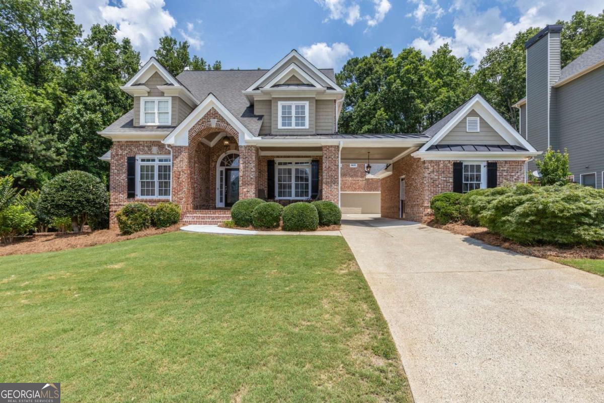 Showcasing this meticulous stunning Porte-cochere home in Bridgemill Golf & Country Club welcomes you with manicured landscaping, freshly rebuilt front brick steps and sidewalk (March 2025), and a classic brick front porch. Fresh interior and exterior paint, newly installed carpet, and polished hardwoods throughout the main level give the home a crisp, move-in-ready feel. Set on a large corner lot with privacy provided by lush, protected forest and west-facing streetside, this residence offers exceptional space both indoors and out. Inside, the layout is both elegant and functional, beginning with a formal living room and formal dining room that flow easily into the heart of the home. The kitchen features rich stained cabinetry, granite countertops, and a center island-ideal for both everyday use and entertaining. The family room is wired for surround sound and centers around a stacked-stone fireplace with a gas starter and wood-burning option. Architectural cut-outs provide sightlines between rooms, and huge main-level windows allow visibility from the front door to the serene backyard. Smart features include two smart thermostats, smart garage door sensors and controls, and Ethernet wiring for high-speed internet and easy home networking. This home has 5 generously sized bedrooms, each with its own en suite bathroom and walk-in closet. The primary bedroom has a trey ceiling, along with two sitting areas and flows into a vaulted bathroom with dual vanities and a large tiled shower. Recent mechanical upgrades include an upstairs HVAC unit (January 2024), a main-level A/C condenser motor (July 2023), and a professionally soft-washed roof (2025). Bridgemill is surrounded by mature trees and protected Corps of Engineer property, with walking trails that offer peaceful escapes from daily life. Optional community amenities include an 18-hole golf course, tennis and pickleball courts, a two-acre pool, and a state-of-the-art fitness center. Conveniently located near shopping, dining, parks, Lake Allatoona, and commuter routes via I-575 and Peach Pass, this beautifully updated home is move-in ready and available for a quick close-just in time for the new school year. Discounted rate options and no lender fee future refinancing may be available for qualified buyers of this home.