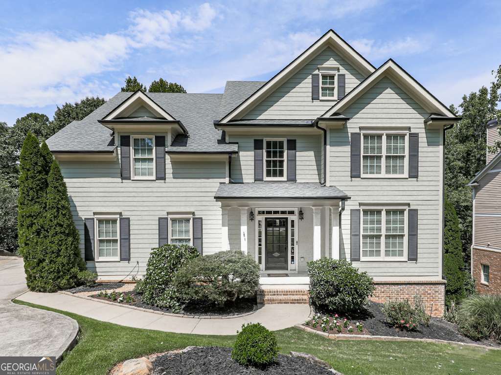 This beautiful 7 bedroom, 5 bath home in the sought-after River Green community offers timeless craftsmanship and modern luxury. As you enter the dramatic two-story foyer, you'll note the arched doorways, wrought iron railings, intricate crown molding, heavy base molding, and hardwood floors that set the stage for gracious living. The expansive family room with its soaring, coffered ceiling, elegant columns, and gas-log fireplace create a warm, welcoming atmosphere while oversized windows fill the space with natural light. Just off the family room is a full bedroom and full bath perfect for guests or family who need main level living. The family room opens to the spacious, open kitchen complete with a large center island and premium finishes that boast expansive granite counter tops, upgraded cabinets for plenty of storage, stainless steel appliances, double oven, gas cook-top, built-in microwave, built-in desk, and is designed for both convenience and entertaining. The kitchen opens to the large back deck overlooking the very private, wooded back yard. Just off the kitchen is a very handy "Butler's pantry" now used as a coffee station. The large, walk-in pantry is located here. Moving ahead you'll enter the huge dining room with crown molding, chair railing, updated chandelier, seating for 10 or more, and plenty of space for entertaining. Adjoining the dining room through a dramatic archway is a large room that can be a living room or more formal flex space. Upstairs, the luxurious master suite offers a serene retreat with soaring tray ceiling, heavy moldings, sconces, and an elegant archway to the sitting room with custom built-in bookcases, columns, and a cozy window seat. The huge master bath has separate, his and her vanities, updated fixtures, large separate shower, jetted tub, oversized walk-in closet, and separate toilet area. All secondary bedrooms connect to a full bath and are generously sized (one has a walk-in closet) and each bedroom provides versatility for family, guests, or home office needs. Also upstairs, you'll see the huge bonus room ready for entertainment, media room, office, etc. Downstairs, the fully finished basement features a second kitchen, 2 full bedrooms with walk-in closets, full bath, a theater room, full workshop, and abundant living space ideal for in-law or teen suite, entertaining, or a private getaway. Step outside to enjoy the park-like, very private, wooded backyard from the large stone patio featuring a large firepit. Enjoy River Green's premier amenities including a catch-and-release lake, 3 swimming pools, walking trails, tennis, park, playground, clubhouse and more. This is a rare opportunity to own an elegant home in one of the area's most desirable neighborhoods. Come and see. You'll be glad you did.