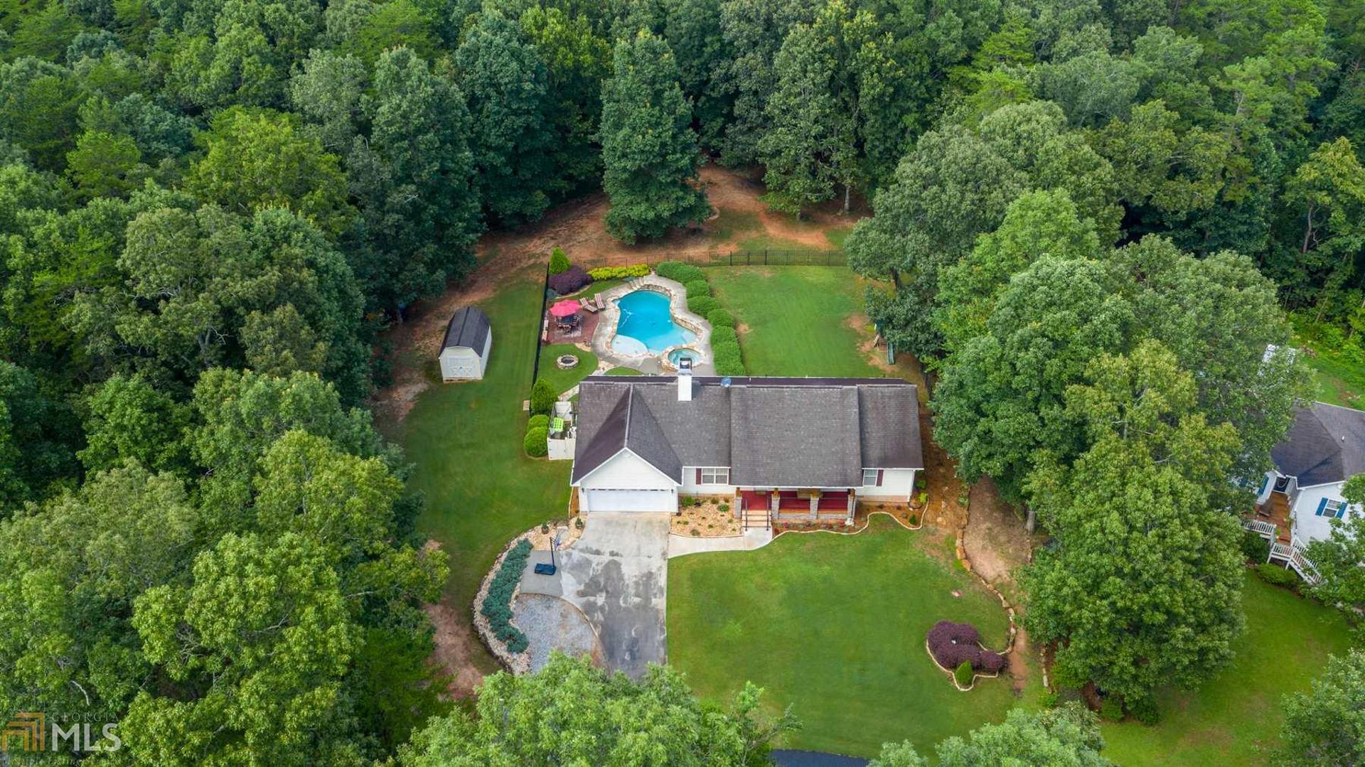 Beautiful 3/2 stepless ranch w/ SALTWATER POOL! Gorgeous home features gleaming hardwoods in the living areas. The roomy great room has a beautiful stacked stone fireplace and trey ceilings. The large kitchen kitchen features kitchen with custom (white) all wood cabinets, large dining area that will seat 12, and beautifully patterned hardwood floors! The oversized master bedroom is carpeted and a private bath with tile flooring, double vanities and large walk in closet. The home features a rocking chair style covered front porch front that over looks a gorgeous sodded. (Bermuda grass) lawn. BRING YOUR SWIM SUIT! The back yard features a pool with two waterfalls, an extra large tanning ledge, spa, and flagstone fire pit! The pool area tastefully done in flagstone and concrete and fenced with black wrought iron fencing. Also inside the fenced area is a large grassed area for playing! The home sits on a flat 1.01 acre lot, and there is plenty of the lot that is not fenced with the added benefit of car, truck or RV access to that area. There is also a wooden barn style storage building on the lot. The mountains can be seen in the distance in the wintertime! The location is a big plus as GA 400 is a straight shot and only 5.8 miles away. You are only 6.6 miles from the quaint, historical Dahlonega Square, 20 miles from NE GA Medical Center and Hospital in Gainesville and 11 miles from Cleveland, GA! It is a great central location! This home has been upgraded and updated and immaculately maintained … it won’t last long!!