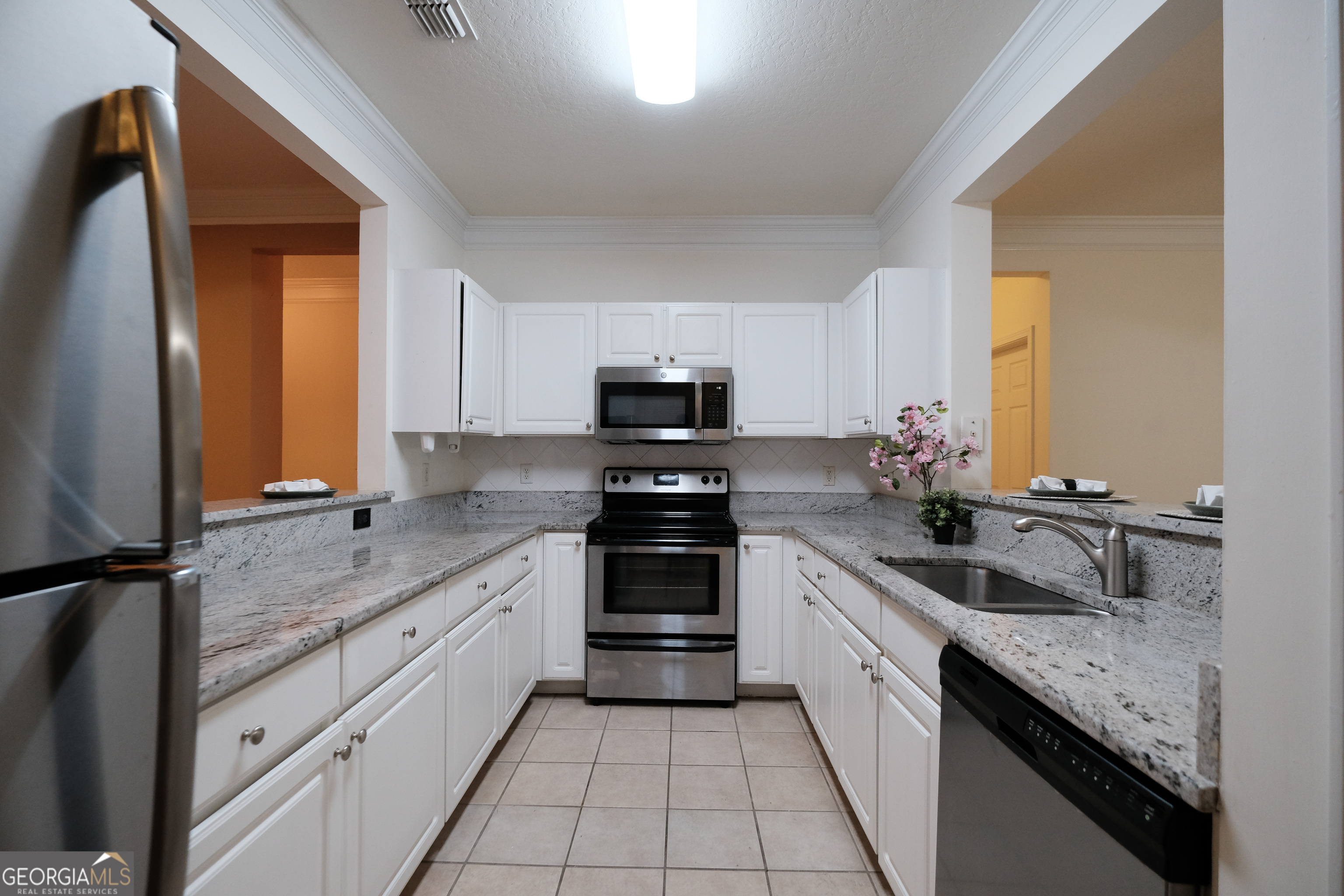 Located just a mile off I-85 and tucked into a peaceful valley of mature trees, this main-floor 3-bedroom, 2-bath condo offers the perfect blend of comfort, convenience, and low-maintenance living. Step inside to a tile-lined foyer that opens into a well-planned semi-open layout. The updated kitchen offers clear sight lines to both the living room and full-sized dining area, making it easy to stay connected while entertaining or enjoying quiet evenings at home. The "split roommate" floor plan provides optimal privacy, with the spacious primary suite situated on one side of the home. Enjoy a walk-in closet, private access to the patio, and a large ensuite bath. On the opposite side, two secondary bedrooms share a full bath and offer generous closet space. A cozy bonus nook at the end of the hall makes an ideal home office, play area, or reading corner. One of the rare perks of this unit is the deeded one-car garage just steps from the entrance. Its elongated layout includes extra storage space, perfect for bulk shopping or seasonal items. Community amenities include a pool, tennis courts, an exercise facility, a dog park, and even a movie theater. Prefer city adventures? You're just about 15 minutes from Buckhead, Sandy Springs, and Midtown, with endless dining, shopping, and entertainment options. With exterior and grounds maintenance covered by the HOA, this home offers a truly worry-free lifestyle. Don't miss your chance-schedule your private tour today!