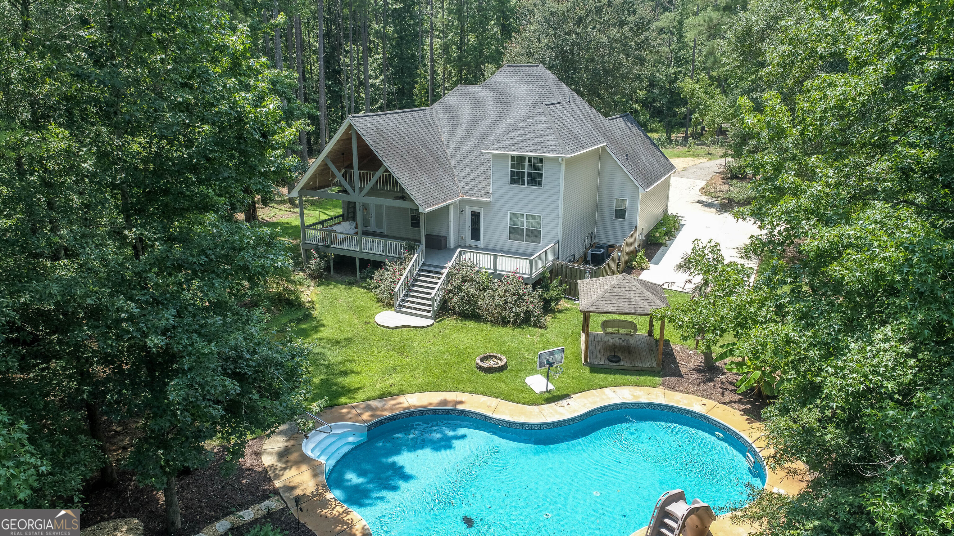 Private 1.55 Acre Property with Pool, Detached Garage, and No HOA! This 3-bed, 2.5-bath home sits on a gated, fully fenced 1.55-acre lot with a long list of updates. Inside, you'll find LVP flooring throughout, white quartz countertops, a spacious master on the main with direct access to the back deck, plus two bedrooms and a large bonus room upstairs. The back deck runs the full length of the home and features a vaulted gabled ceiling finished in tongue-and-groove, a bed swing, and a ladder-access play loft. The saltwater pool was completely updated within the past year, including a new liner, pump, electrical, and grounding. It's beautifully landscaped and includes a water slide and gazebo sitting area. The detached metal garage/workshop has high ceilings, full electrical, and there's a concrete pad for RV or camper parking. Water heater and dishwasher are both newer. No HOA, very private, and a great setup for anyone who needs space to spread out or run a business from home.