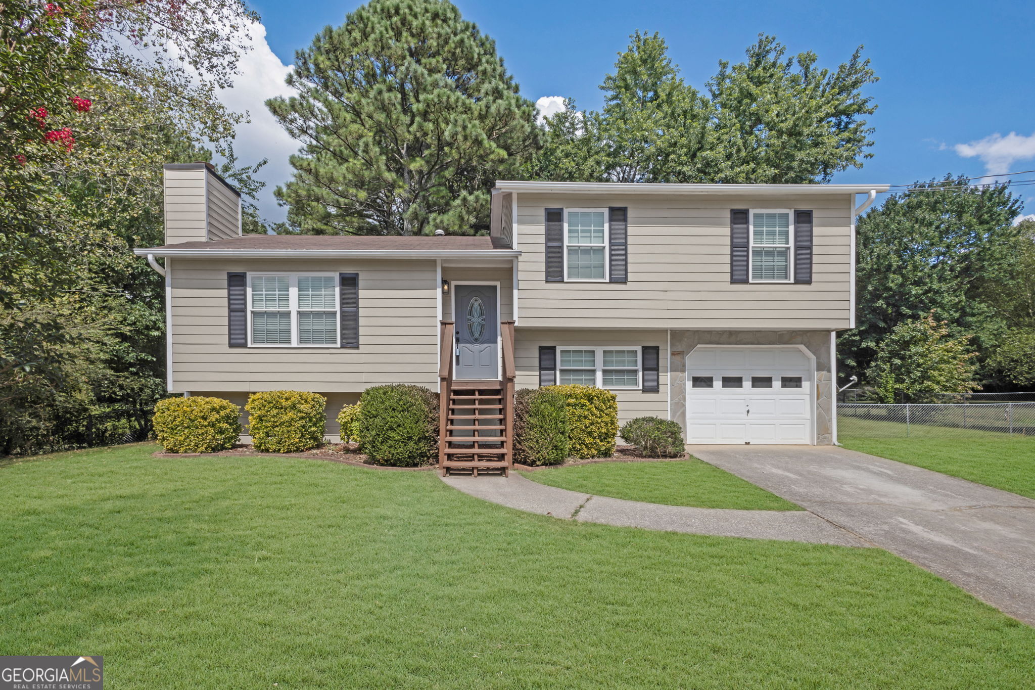 Check out this newly updated home in Douglasville, GA, offering a perfect blend of modern upgrades and charm! It's an ideal starter home situated in a quiet neighborhood, complete with a large, level lot and stunning mature trees. Inside, you'll find vaulted ceilings in the family room, complemented by a cozy stone fireplace. The open-concept kitchen provides a clear view of both the family room and dining area, making it perfect for entertaining. The dining room seamlessly extends to a spacious deck, offering an incredible view of the large, fenced backyard, which provides ample space for various activities. Upstairs, the home features a master bedroom with a private bath, along with two additional bedrooms that share a separate bathroom. The entire house is move-in ready, having just received fresh paint both inside and out, as well as new flooring throughout. Its location provides quick access to shopping, dining, and groceries, and it's just minutes from HWY 20 and local attractions like Sweetwater Creek State Park and Six Flags Over Georgia. Plus, there's no HOA! This is truly an opportunity you won't want to miss.