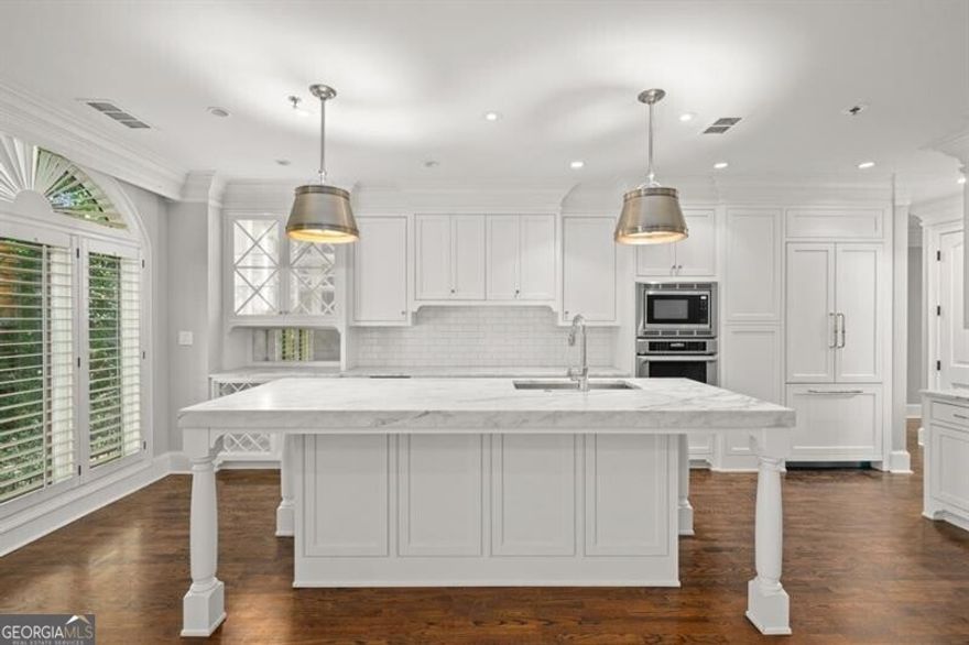 Welcome home to the coveted boutique community of Halten Hall in the heart of Buckhead. This is an exclusive opportunity to live in one of the 15 residences, with only two residences per floor, which share a private lobby area. This impeccable unit offers ultimate privacy and showcases superior craftsmanship and design. The location is ideal, only a short walk to Buckhead Village District, where you'll enjoy the best in upscale shopping & dining. This main-level condo features a chef's dream kitchen with Calcutta gold marble countertops, a huge oversized island with Circa pendant lights, and a custom antique bar backsplash. A wine cooler & ice machine make for gracious entertaining. Newer Thermador appliances, plantation shutters, 9' ceilings, and hardwood flooring. Primary bedroom with two custom closets, travertine bath with oversized soaking tub, and separate vanities. Dual zone A/C. Deeded parking for 2 cars across from the elevator. Personal storage room transfers with the sale.