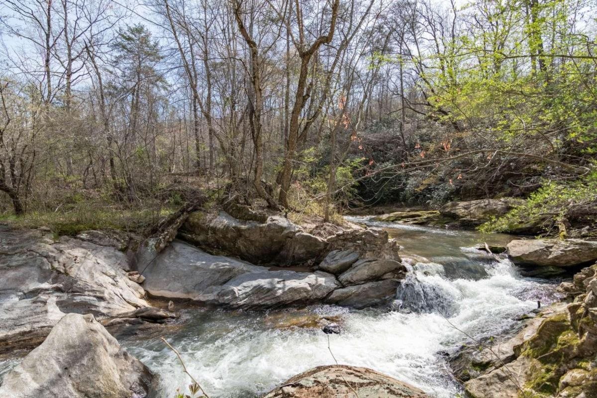 Own your own private "national forest" just outside of Gainesville! Unbelievable private oasis on the site of an old mill. Beautiful shoals, water falls, and approximately 3,300 feet on the West Fork Little River. Cleared pastures and hardwoods make this a functional property. Phenomenal building sites and total privacy make this a hidden treasure. North Hall schools and just minutes to Gainesville. Total of 70 acres on 4 parcels.  Old home on property has no value but rock mill walls add architectural interest!