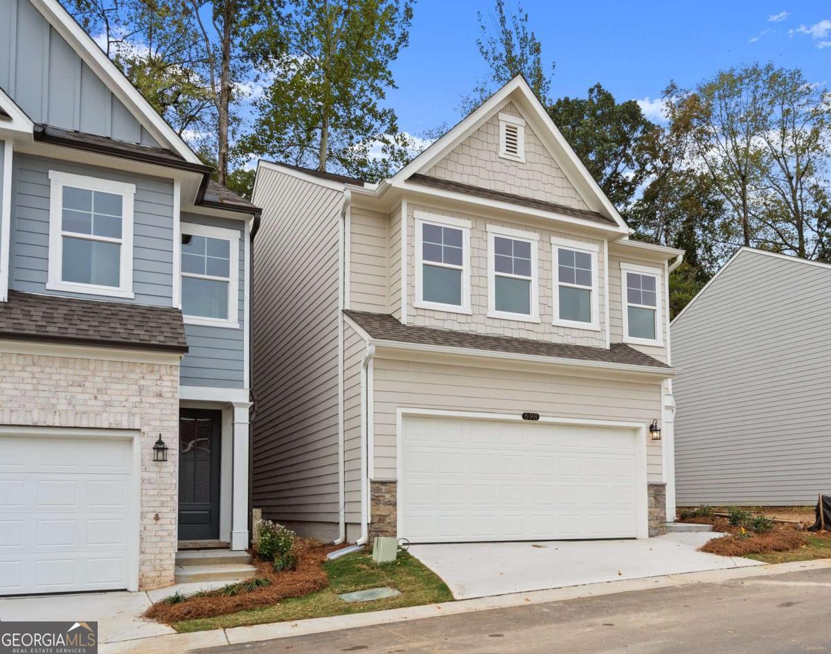 READY NOW!!! Welcome to The Marion A lot 61, a stunning 3-bedroom, 2.5-bath residence in the sought-after GATED Village at Shallowford just steps from pool and clubhouse. This move-in-ready home spans 2,048 sqft, combining elegance with practicality. The open layout invites you into a bright foyer leading to a gourmet kitchen with a large island, 42" cabinets, gleaming Quartz countertops, and top-of-the-line stainless-steel appliances. Relax in the cozy living room, complete with a charming shiplap fireplace and 9 FT ceilings throughout the main level, or entertain guests in the adjoining dining room with easy access to the private patio. Retreat to the oversized primary suite, offering a luxurious extended tile shower and a walk-in closet, providing a peaceful escape from the secondary bedrooms. Lovely backyard for your enjoyment! Enjoy the open railing staircase that adds a feeling of light and spaciousness and oak treads on the stairs enhance the sophisticated ambiance. Set within the ONLY gated community with a pool and clubhouse in Kennesaw, enjoy quality amenities and proximity to excellent schools. With its charming exteriors and open floor plans, this home is a true gem. Self-guided tours available!