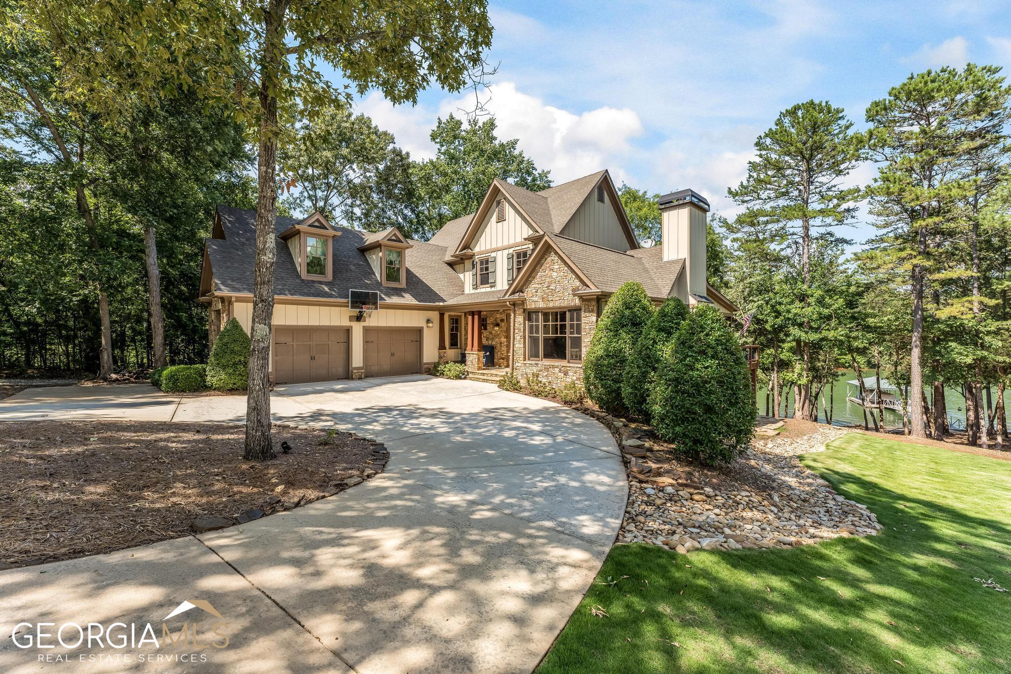 This custom-built home is in one of the nicest settings on Lake Hartwell at the Enclave of Barefoot Bay. The Enclave of Barefoot Bay is a private gated community (with access code only entry) consisting of 5 homes in the Reed Creek area. The lot has a gentle slope to the lake, 12 to 14 feet deep at the dock and is close to the Corp line. This home has been renovated/updated throughout and meticulously maintained. With 5/6 bedrooms, 4 full bathrooms, approx. 5,000 sq ft., and an open floor plan, there is plenty of room for family and friends to gather. On the main level you will find the living room with a beautiful, vaulted wood ceiling and a large floor to ceiling masterfully crafted stone fireplace. Itas the kind of room where you feel like you are in a lake house instead of a house on the lake! Also on the main floor is the newly renovated gourmet kitchen with Brazilian quartzite on the oversized island, new appliances and a built-in wine refrigerator. Itas the place where everyone gathers. There is also an attached oversized two and one-half car garage. The terrace level was also remodeled and includes a media room, a pool table room with wet bar, new beverage cooler, and a second ensuite master bedroom with a full bathroom. There is a lakeside storage garage for all the lake toys (kayak, paddle boards, and other lake toys are included). The media room has an incredible sound system and up to date design features as part of the remodel. The pool table is mahogany with leather pockets and was recently resurfaced with new felt. Technology upgrades include a new security camera system connected to the Arlo app. The 3 HVAC units are connected to the Honeywell app, the lighting control is connected to the Phillip HUE app, and the septic pump monitoring is connected to the Night Eye App. The dock is an upgraded hip roof dock aluminum dock with iron wood on the deck and on the 60-foot gang plank. There is a jet ski dock, lighted pole, wheels on ramp and a lift. There is rip rap on the shoreline which looks great and prevents erosion. This home is a rare find and ready to move in. It is perfect lake home for your family and for entertaining friends. It could also be an income generating property with a comparable neighboring home renting for $850-$940 per night. Convenient to multiple restaurants in Hartwell & Anderson for a nice dinner out by boat. Verbal approval for maximum size dock.