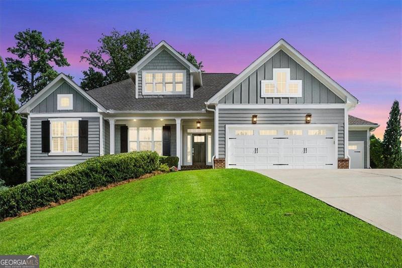Welcome to this beautifully designed 4-bedroom, 3.5-bath residence in the heart of Flowery Branch-a true entertainer's delight! Step inside through the grand foyer with soaring high ceilings, setting the stage for elegance and warmth throughout. Just off the entrance, you'll find a versatile den or office space, ideal for working from home or unwinding with a book. The main level boasts a spectacular open floor plan, seamlessly connecting the expansive kitchen, great room, and dining area-each perfect for hosting gatherings and creating memories. Both the great room and dining area feature cozy fireplaces, while the gourmet kitchen dazzles with a generous island, double ovens, and a gas cooktop, offering an abundance of space to cook, mingle, and entertain. Retreat to the luxurious master suite on the main floor, highlighted by a beautiful tray ceiling and an abundance of natural light. The master bathroom is truly massive, complete with a spa-like soaking tub, separate shower, and a walk-in closet that impresses with four full walls of hanging space and its own bright window. For added convenience, the spacious laundry room with sink is also located on the main floor. Throughout the home, countless windows flood every room with natural sunlight, creating a cheerful, airy ambiance. An open staircase leads to the reverse floor plan's lower level, where you'll find all secondary bedrooms and bathrooms, an extra living room for movie nights or gatherings, plus a handy kitchen area with refrigerator and sink-offering so much flexibility for guests or multi-generational living. This exceptional home combines thoughtful design, luxury finishes, and space galore, making it one you won't want to miss. Schedule your tour today and discover all that this Flowery Branch gem has to offer!