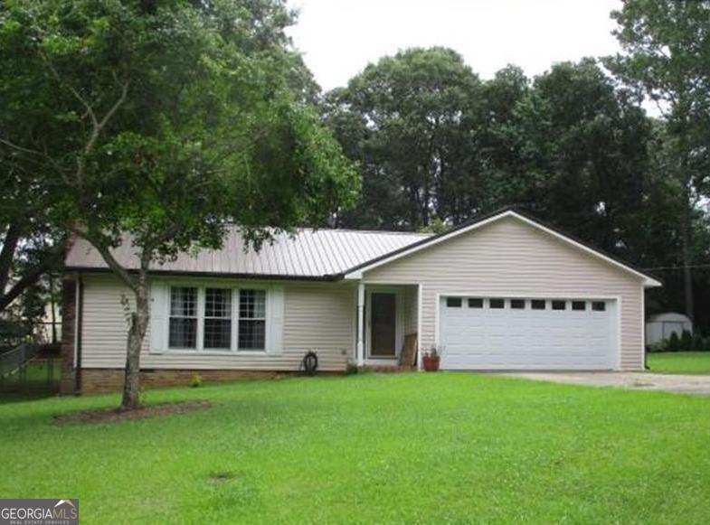 SINGLE LEVEL LIVING in this affordable, functional floor plan on nearly half acre tree shaded lot in convenient location! Level lot with huge deck overlooking fenced backyard. Double car garage and 16 x 16 storage building with matching metal roof to home. Your lifestyle improvement aways mere minutes away as you'll find The Vineyard at Hominy Creek, Fairfield Plantation Resort, Fairfield Recreation Center, The Frog Golf Club, Clinton Nature Preserve, Dog River Reservoir, St Andrews Golf Club and West Georgia Regional Airport.